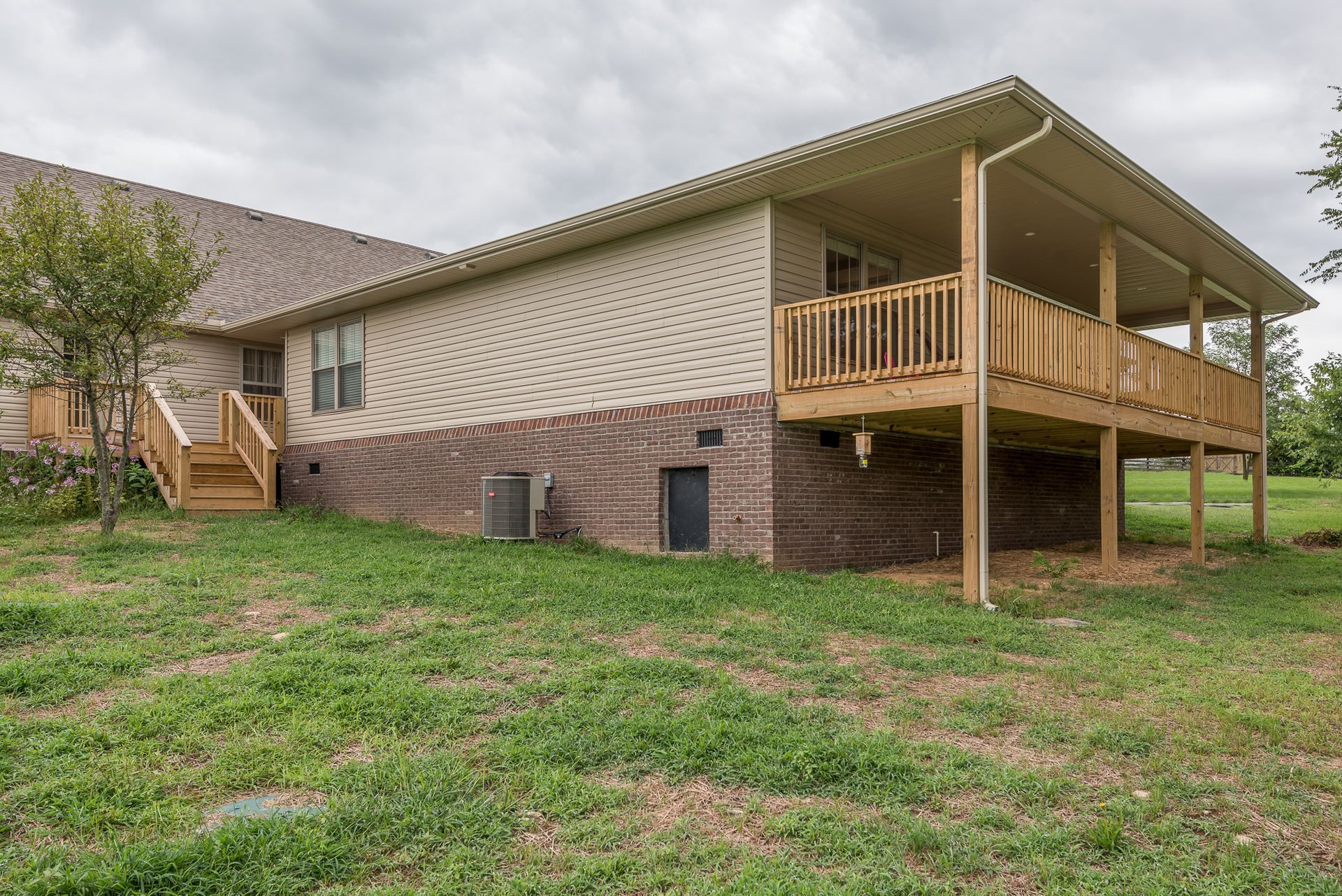 The back of a house with a large deck and stairs.