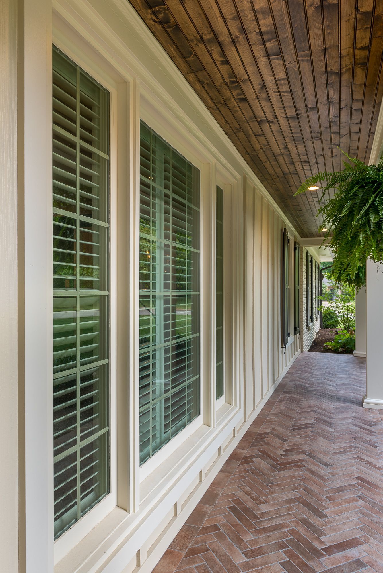 A long hallway with lots of windows and shutters