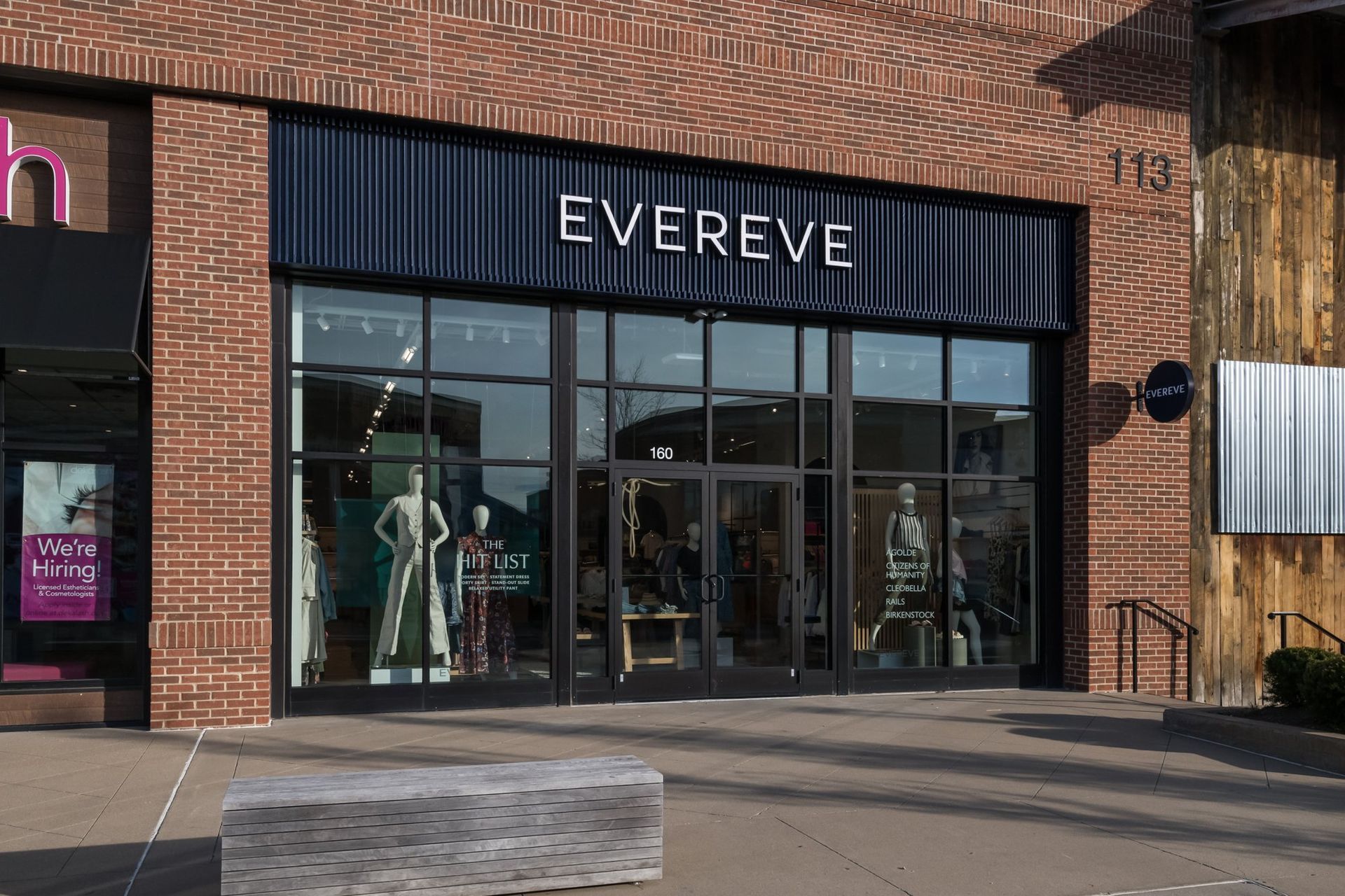 A brick building with a black sign that says evereve on it.