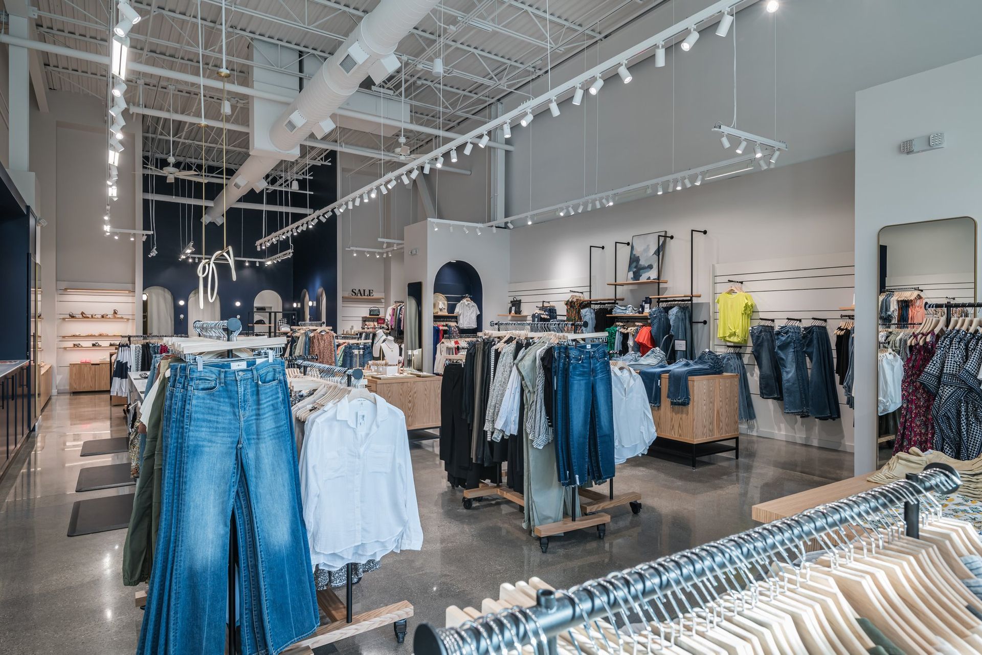 A clothing store with a lot of clothes hanging on racks.
