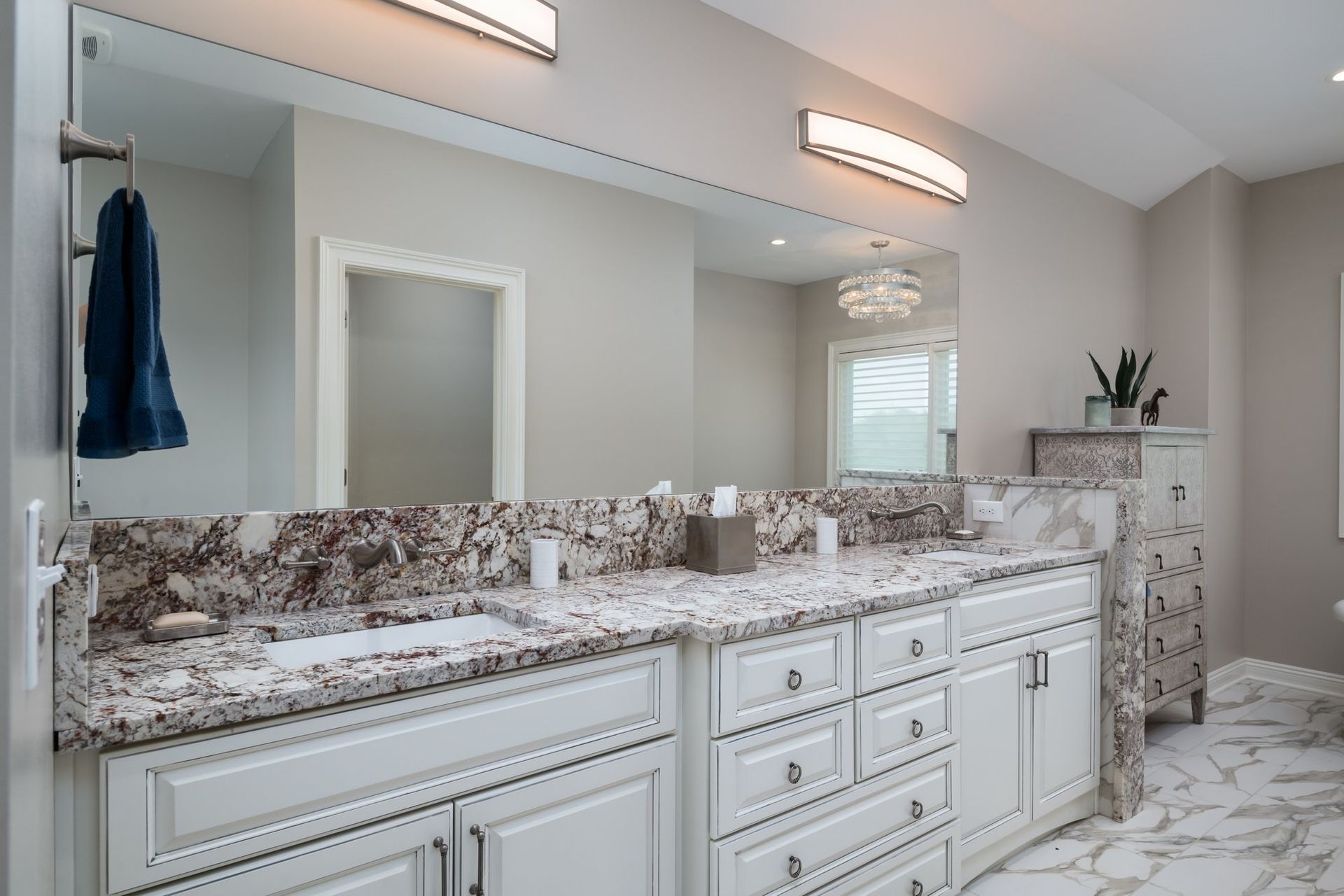 A bathroom with two sinks and a large mirror.