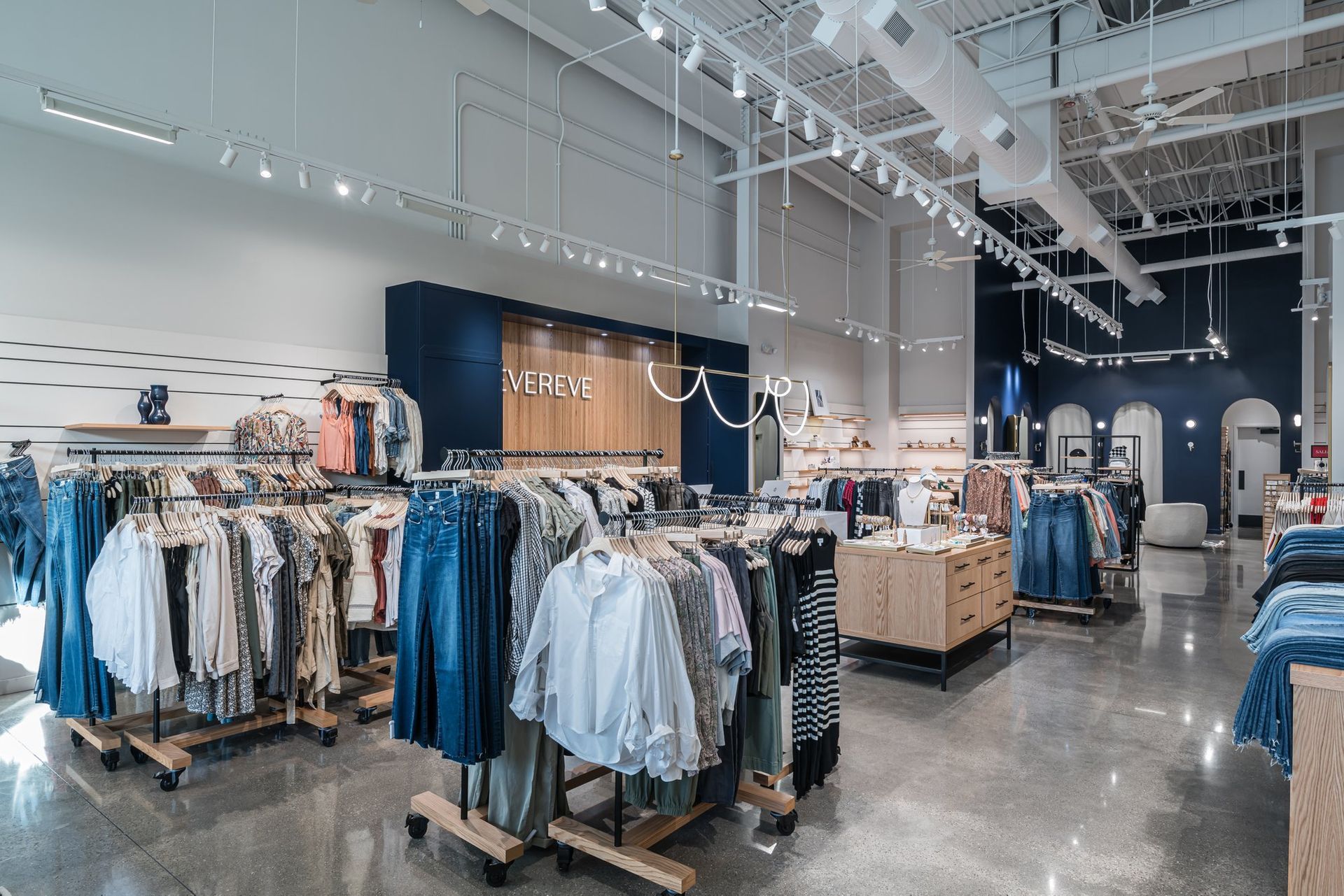 A clothing store with a lot of clothes hanging on racks.
