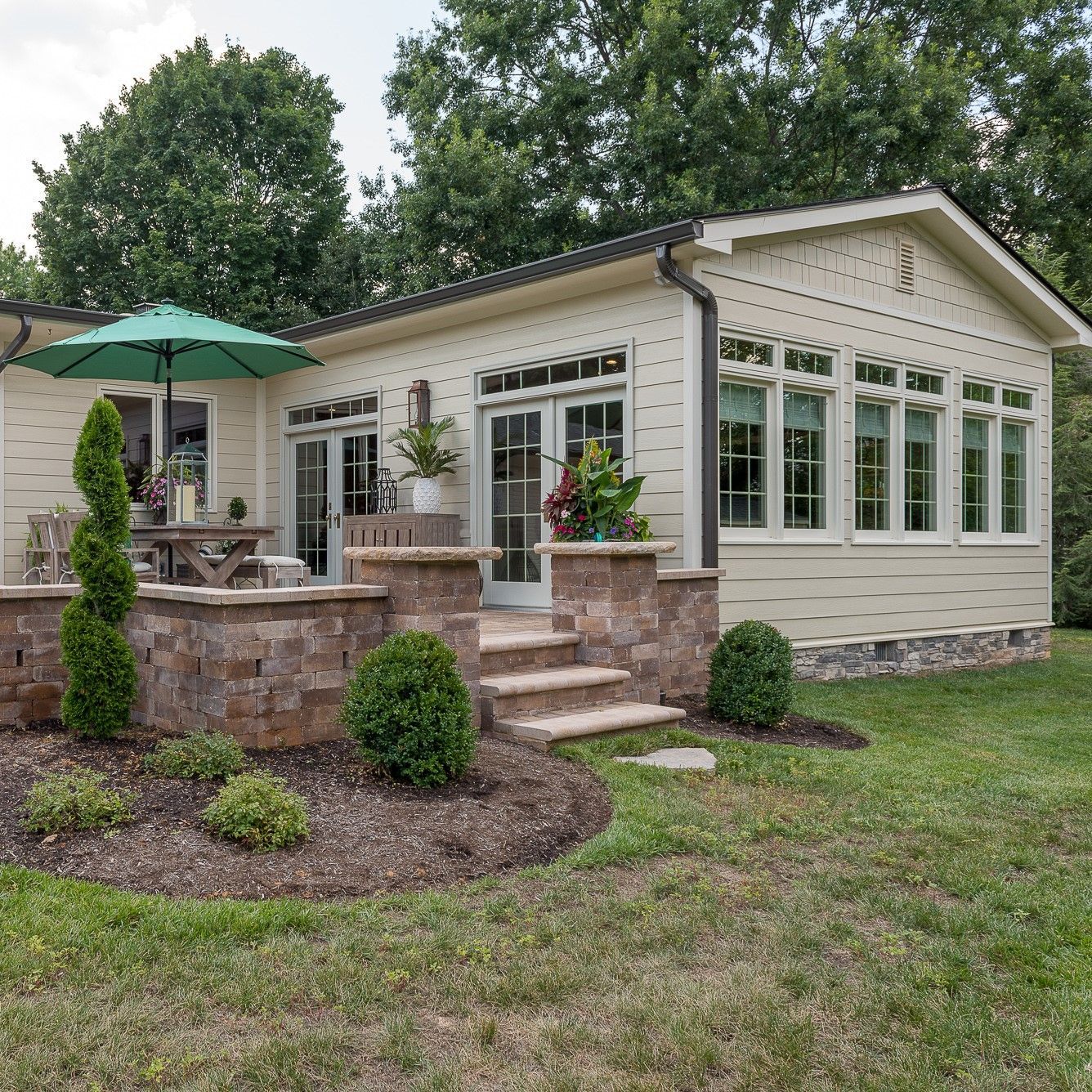 A white house with a green umbrella in front of it