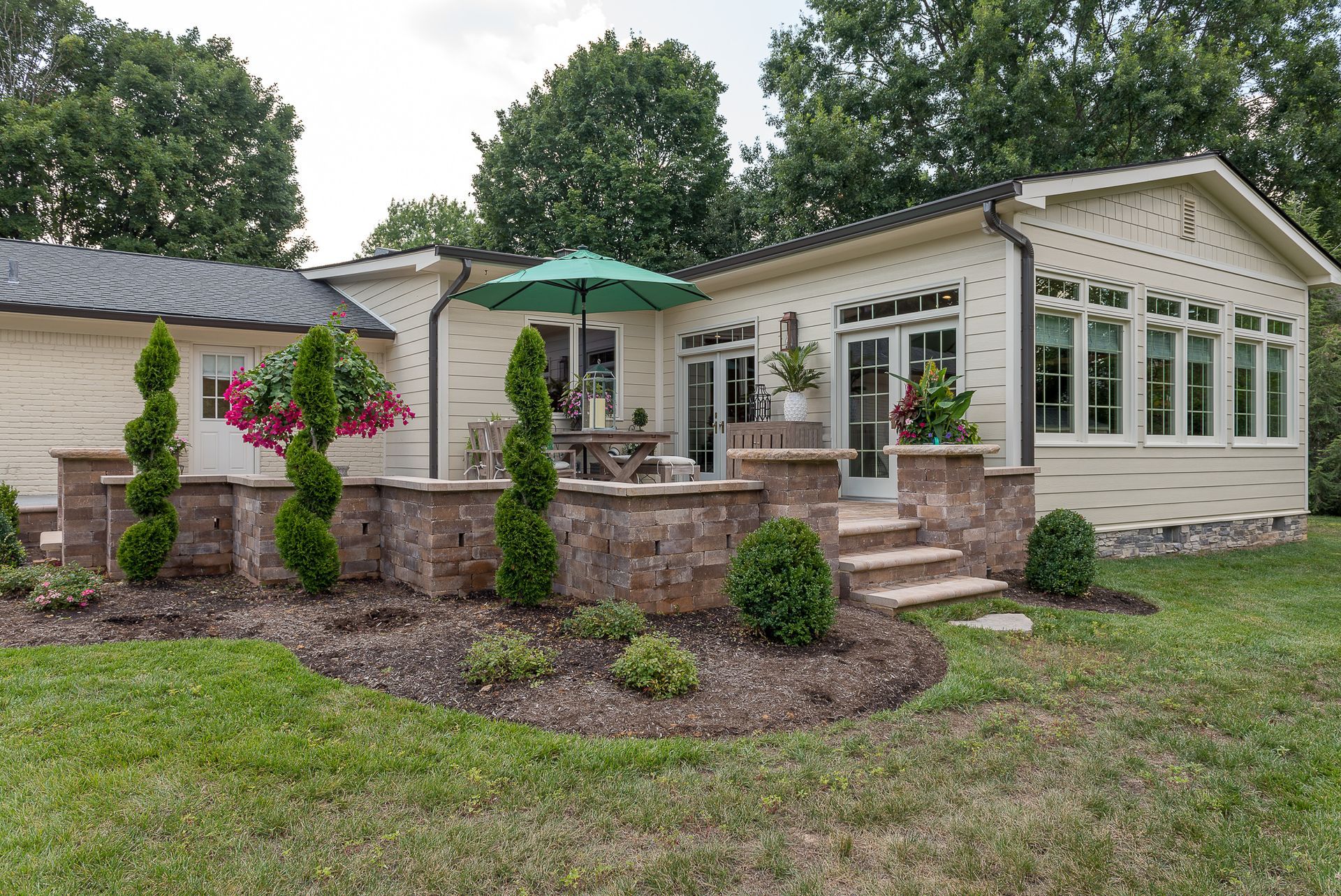 A white house with a green umbrella in front of it.