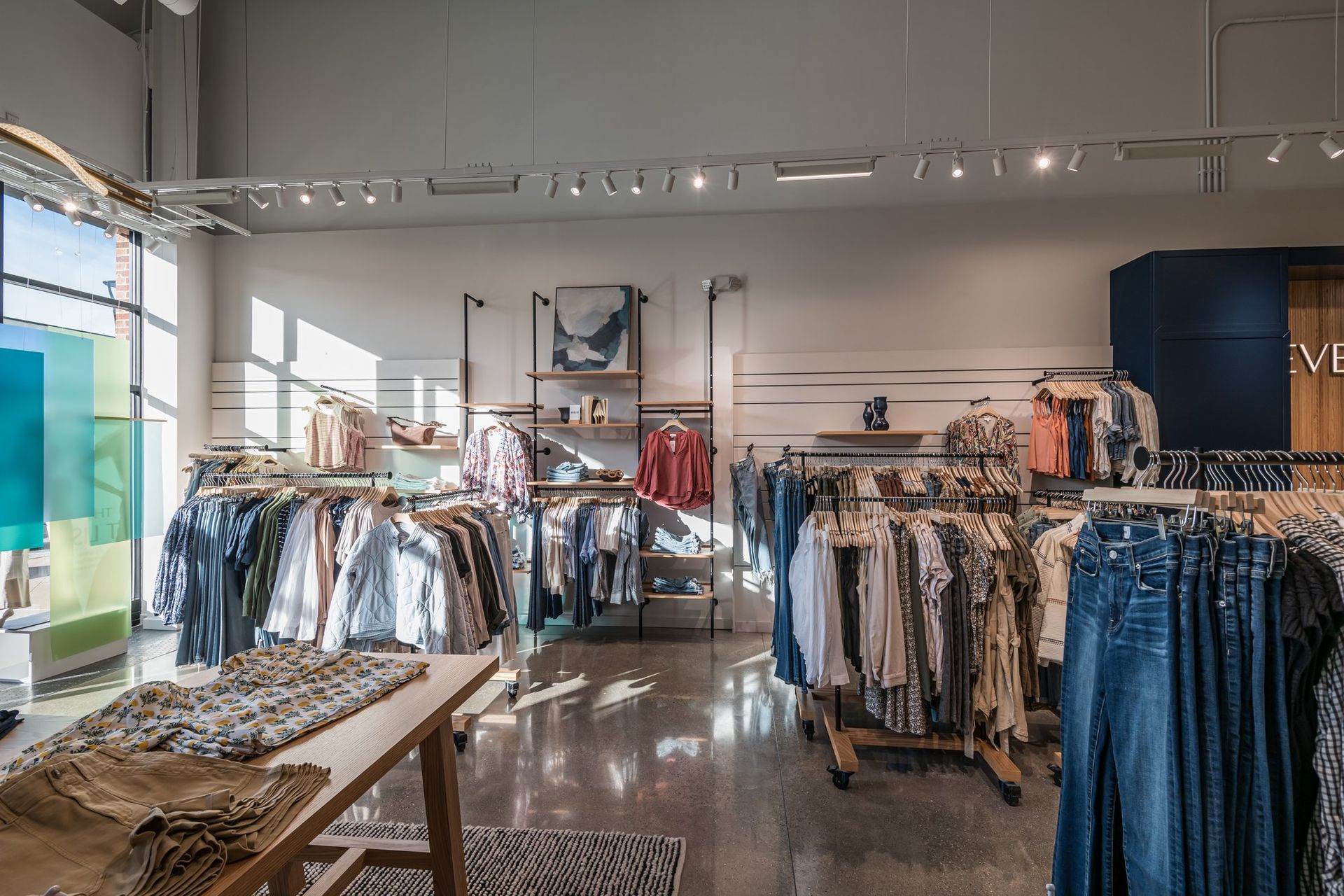 A clothing store with a lot of clothes hanging on racks.