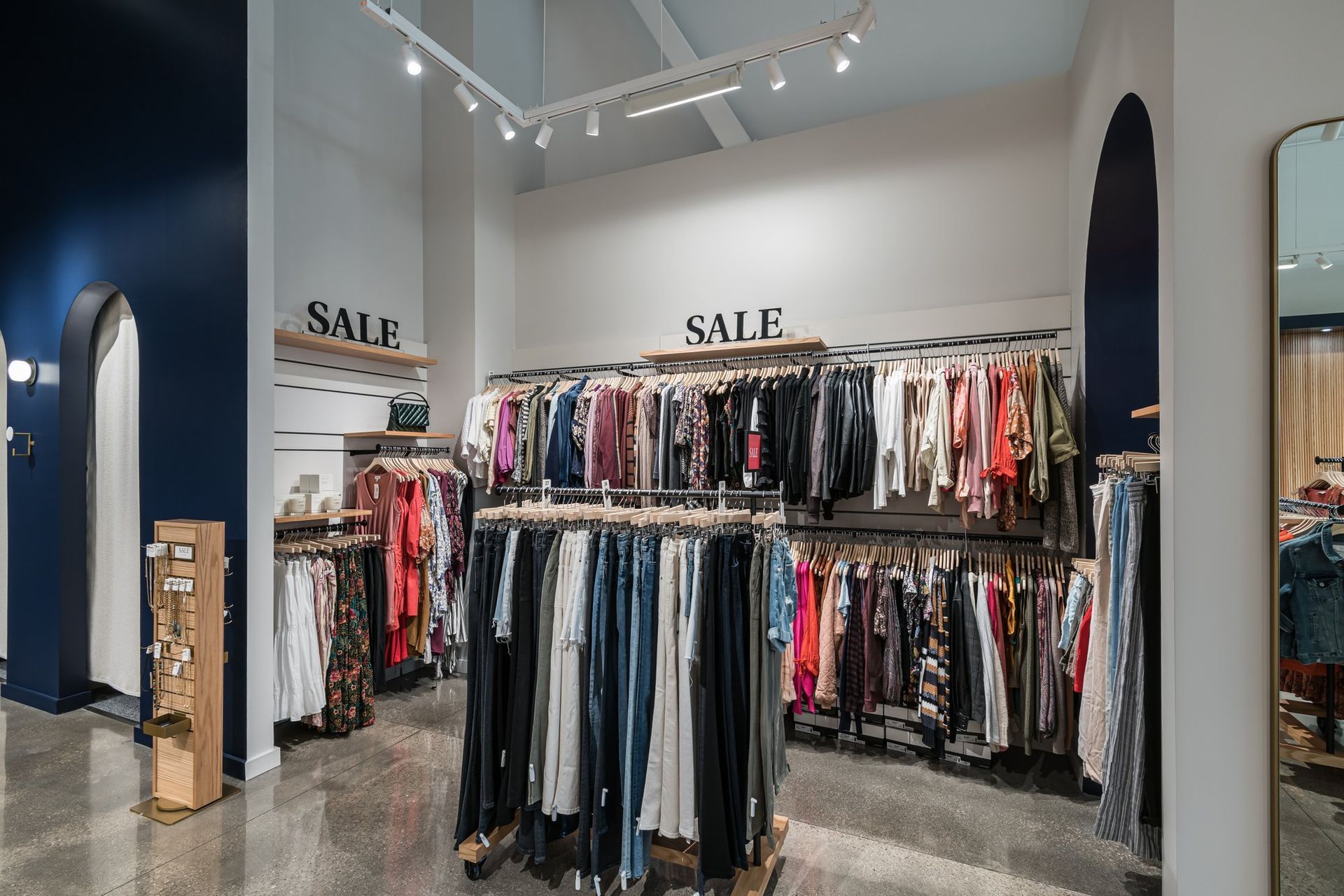 A store filled with lots of clothes and a sign that says sale.