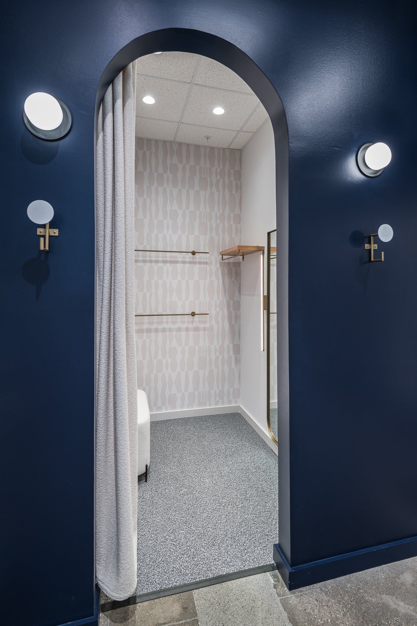 A dressing room with a blue wall and a white curtain.