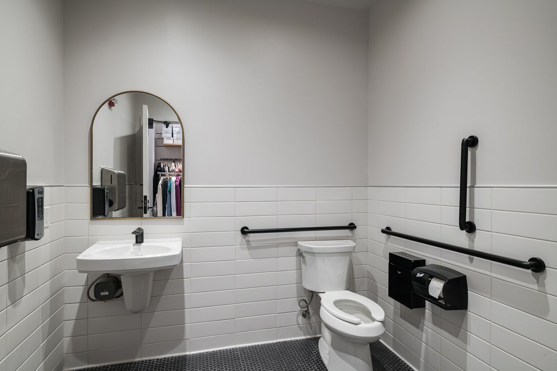 A bathroom with a toilet , sink and mirror.