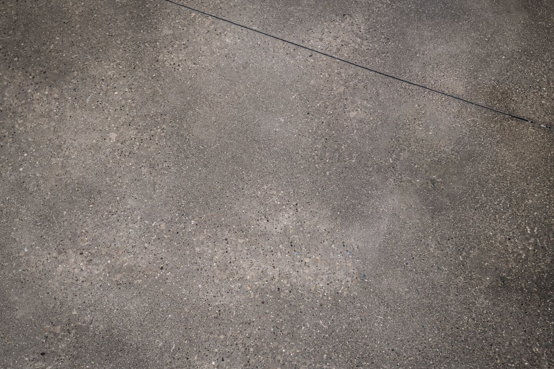 A close up of a gray concrete floor with a diagonal line.