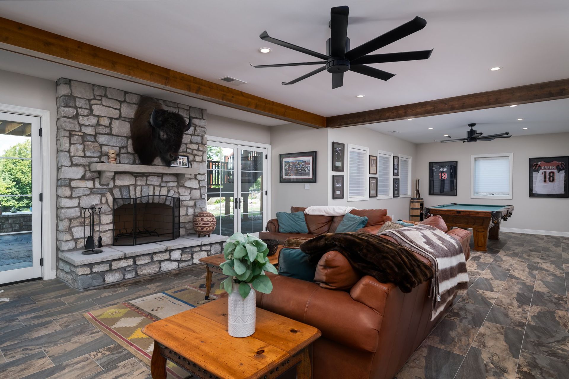 A living room with a fireplace , couch , table and pool table.