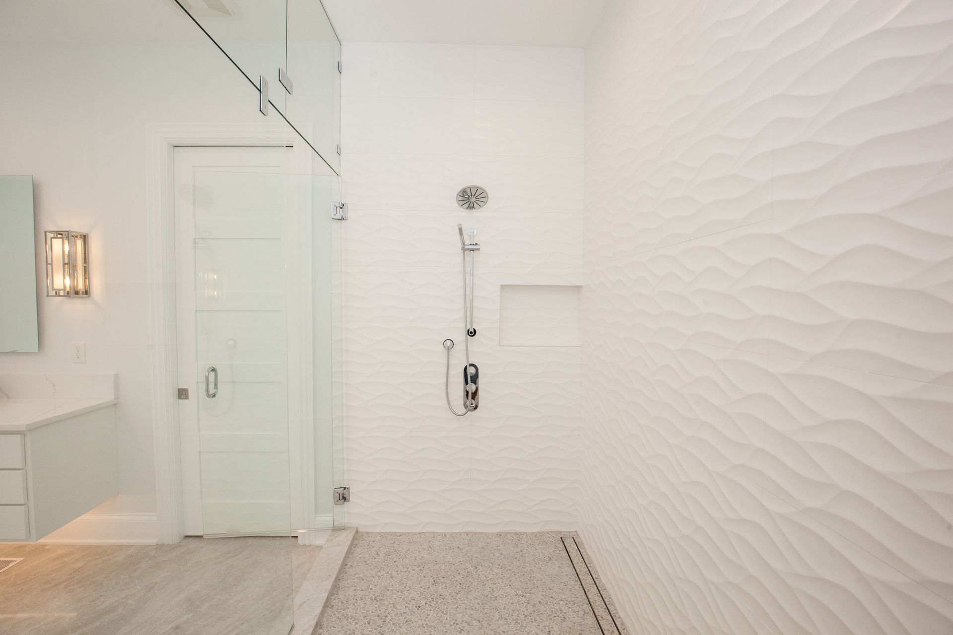 A bathroom with a walk in shower and a sink.