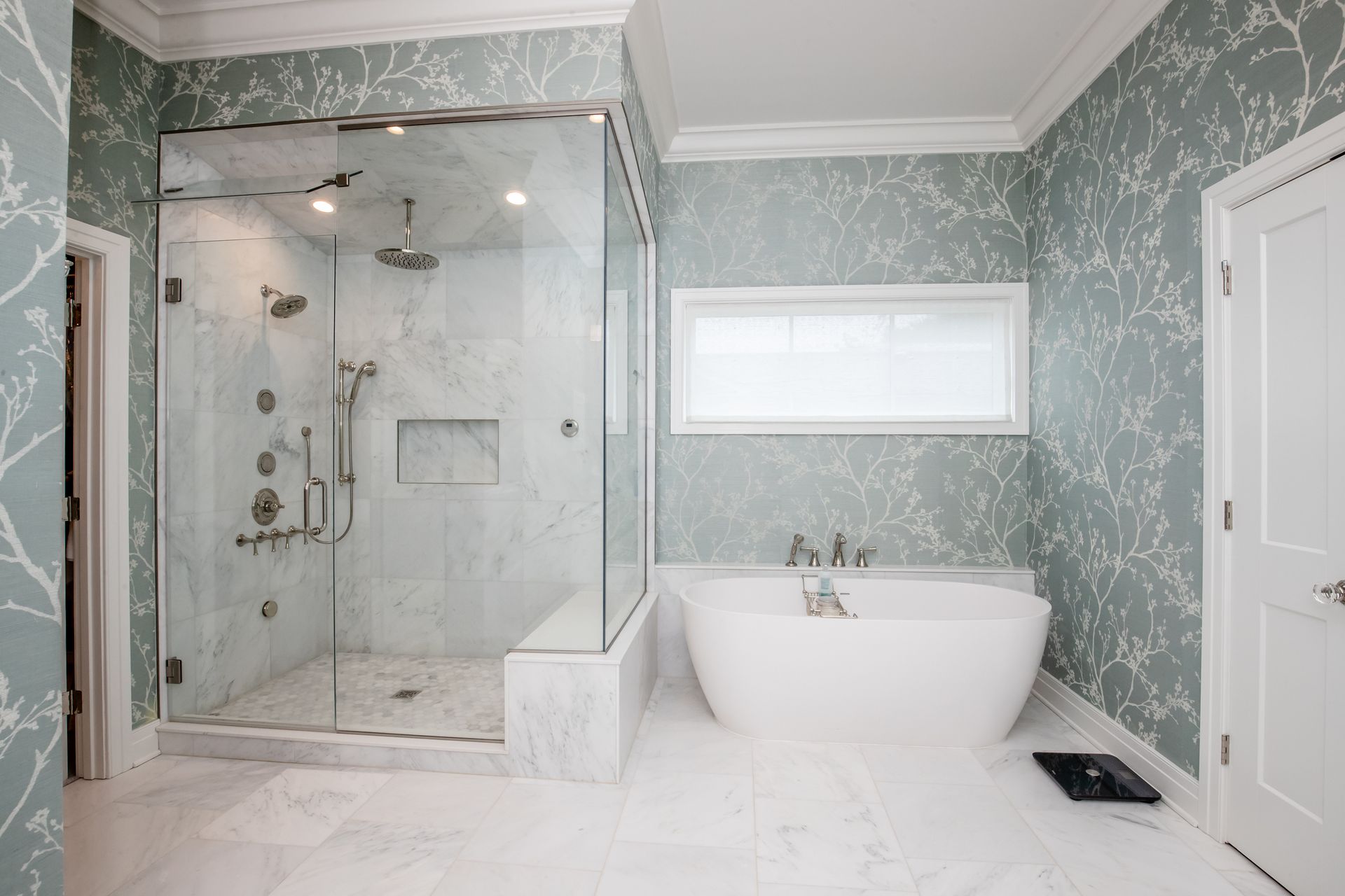 A bathroom with a walk in shower , tub , and window.