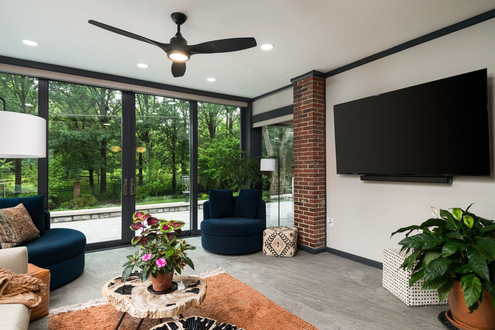 A living room with a flat screen tv and a ceiling fan.