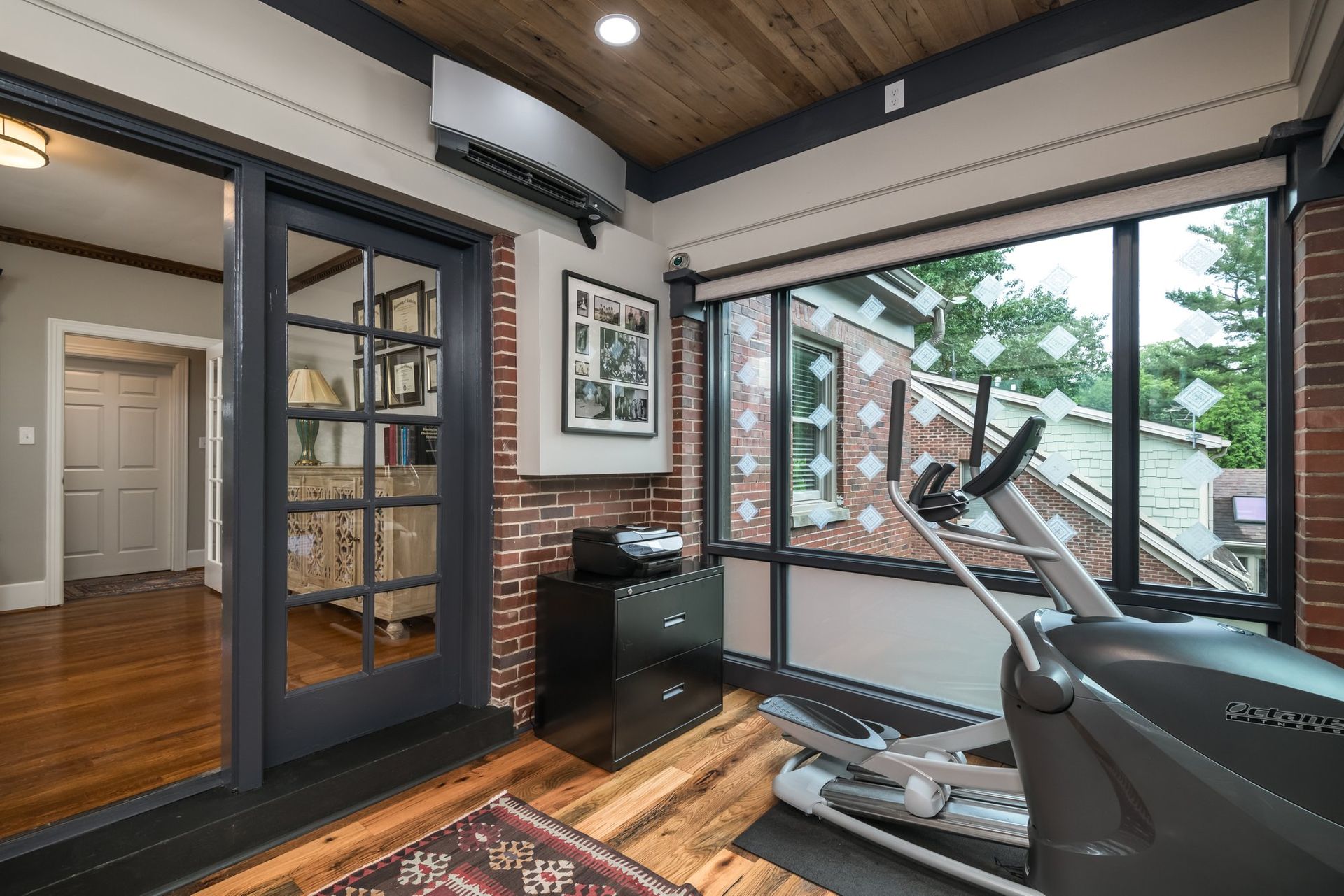 A home gym with a treadmill and a sliding glass door.