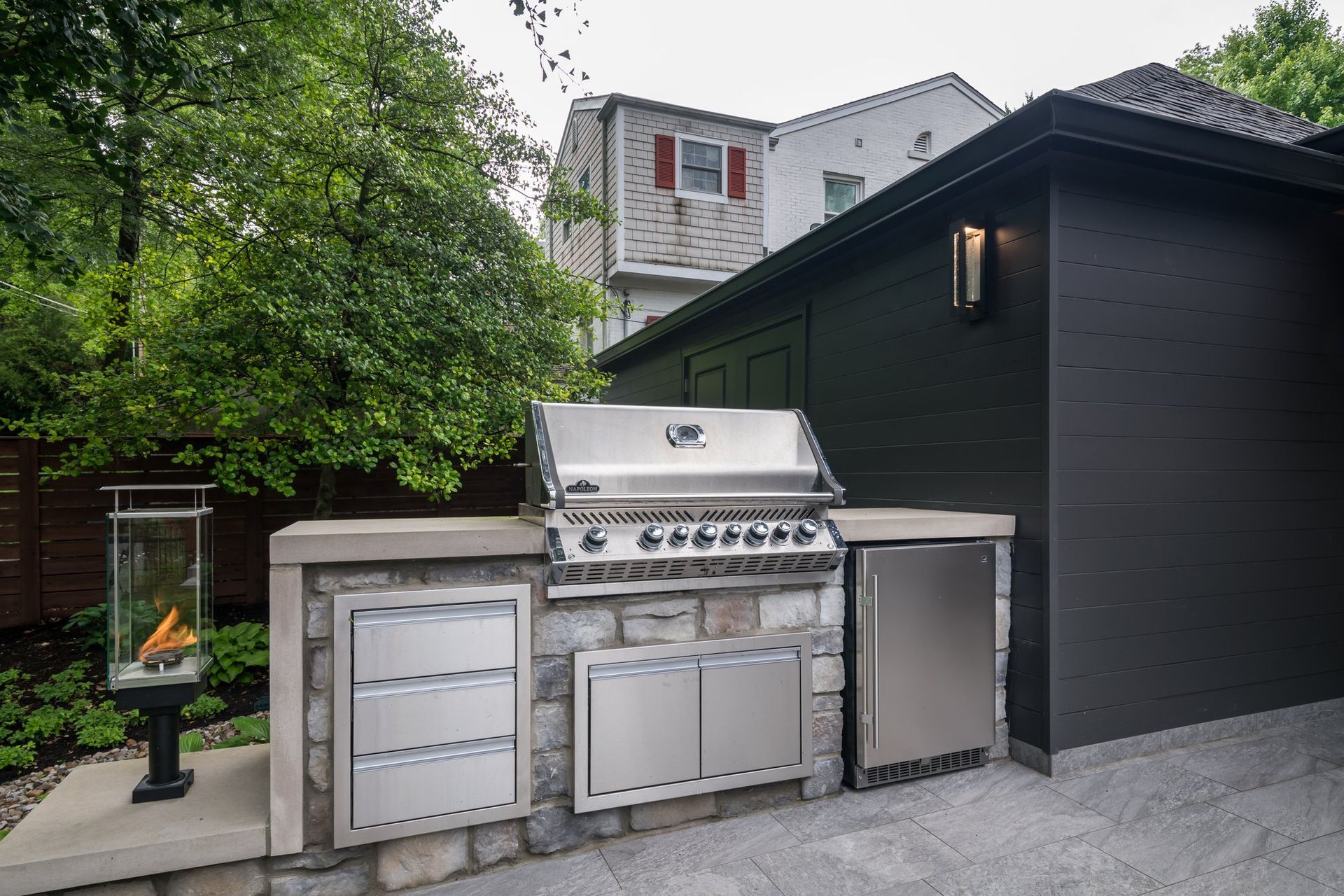 There is a grill in the backyard of a house.