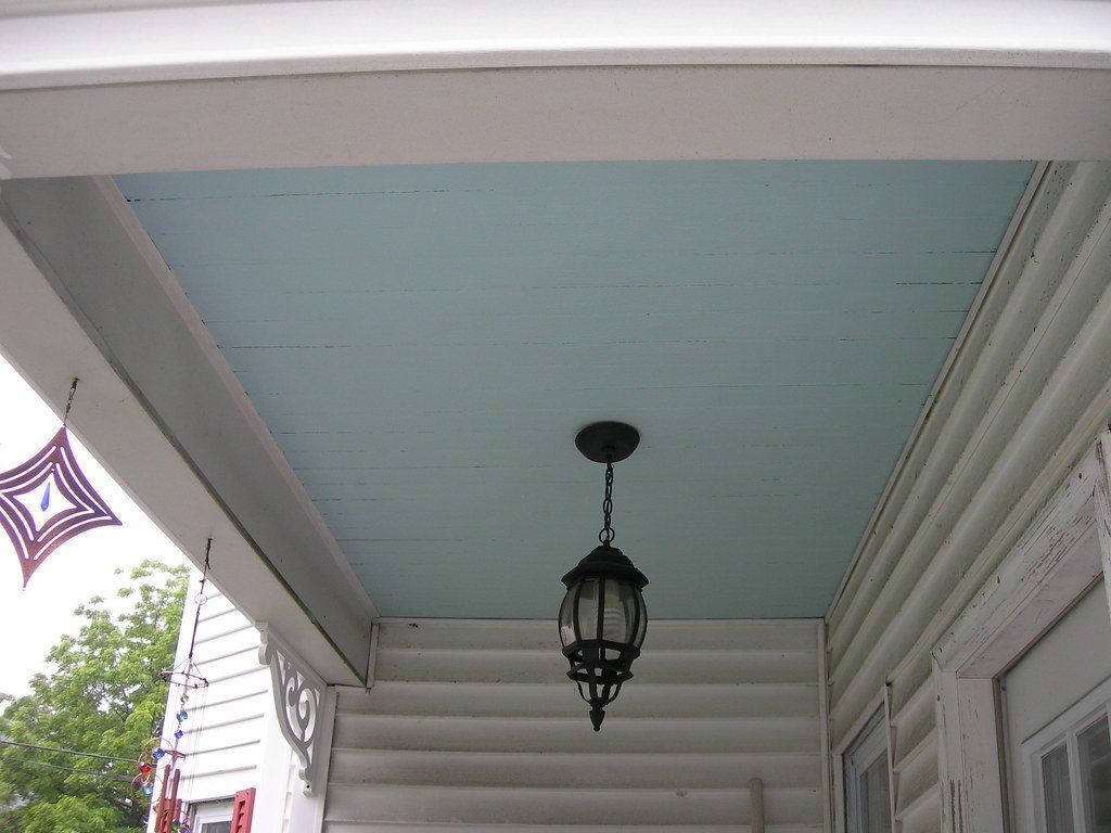 A porch with a light hanging from the ceiling