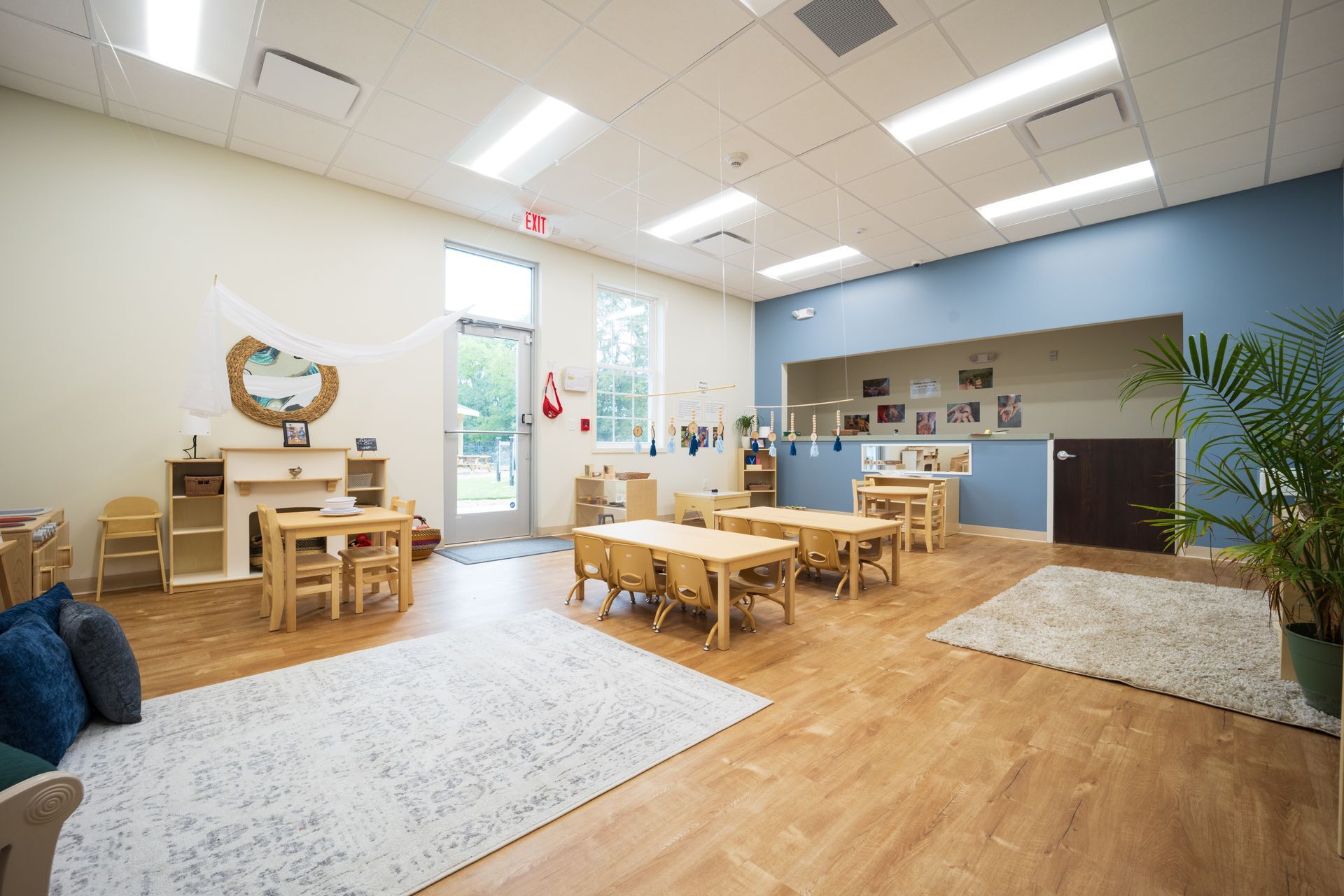 A large classroom with tables and chairs in it.