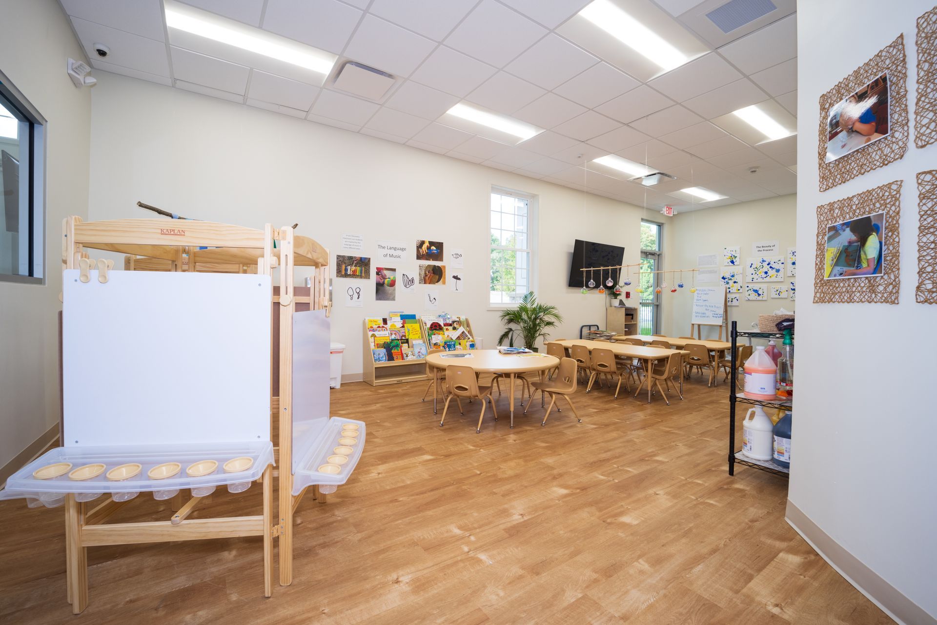 A classroom with tables and chairs and a bunk bed.