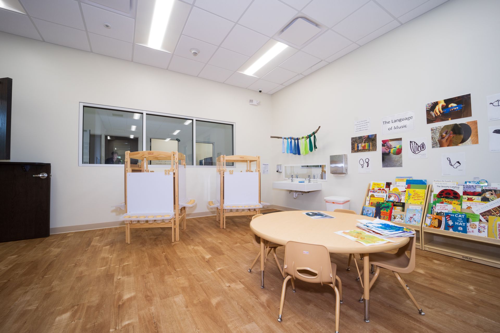 A classroom with a table and chairs and a sink.