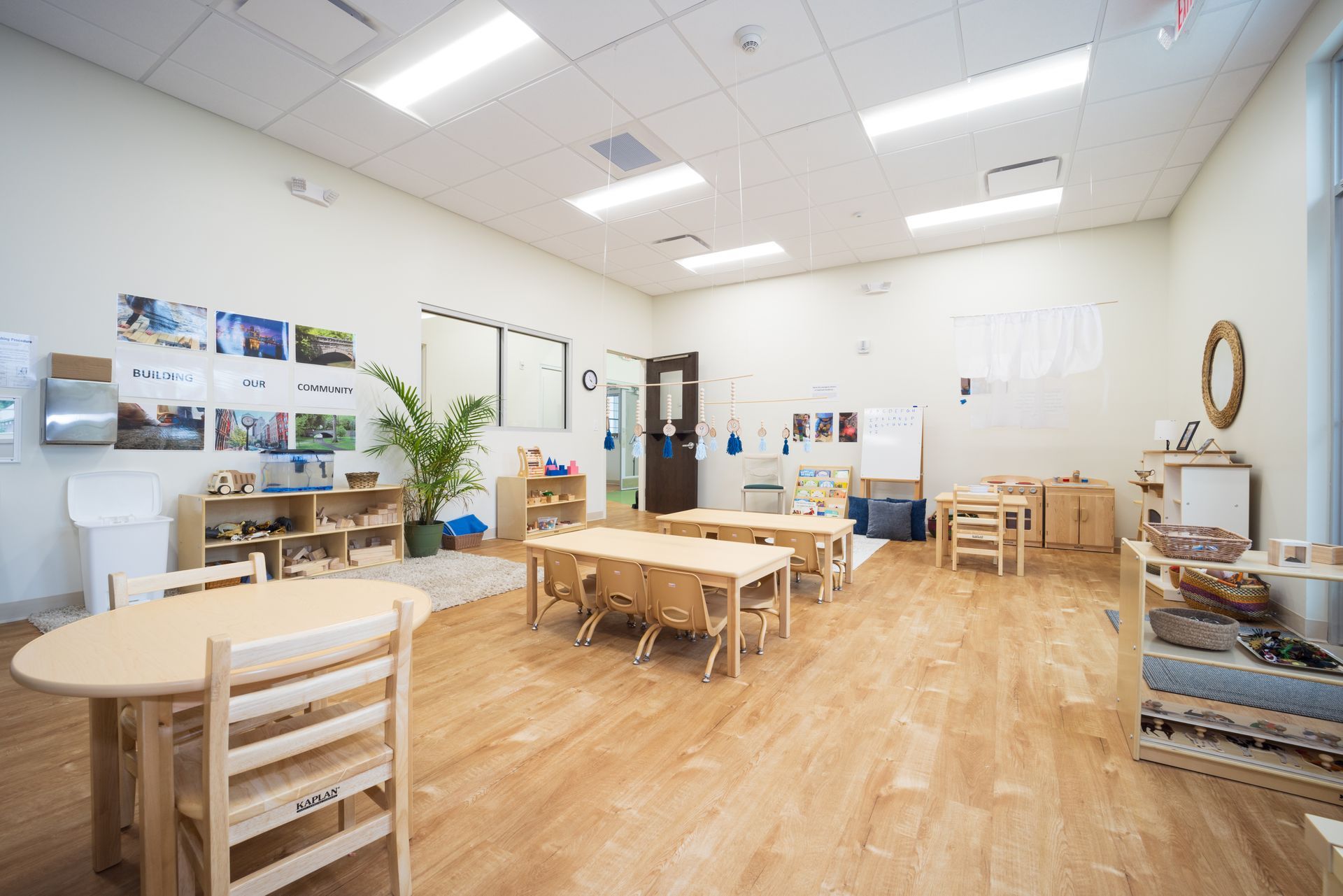 A large classroom with tables and chairs in it.