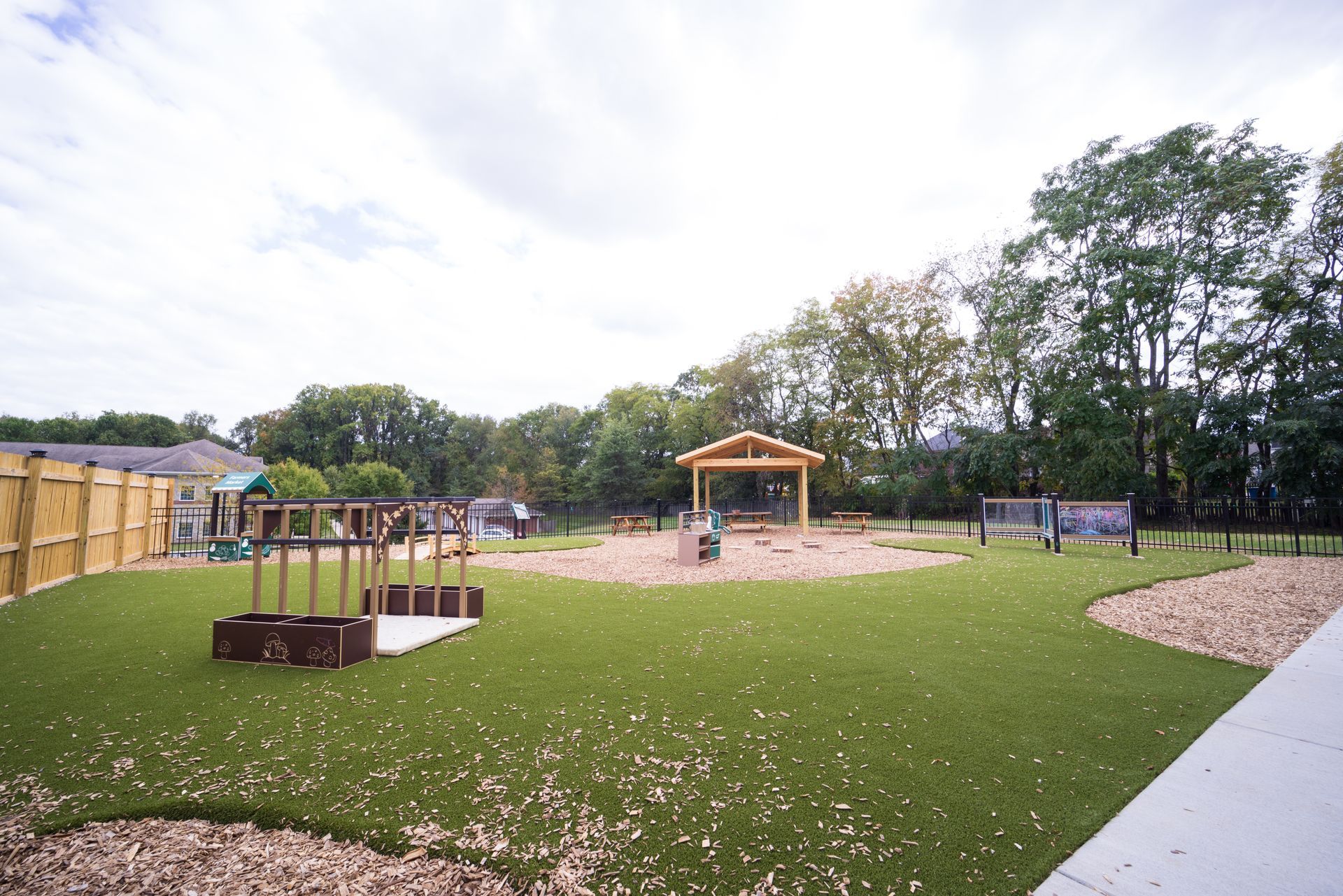 A large grassy field with a playground in the background