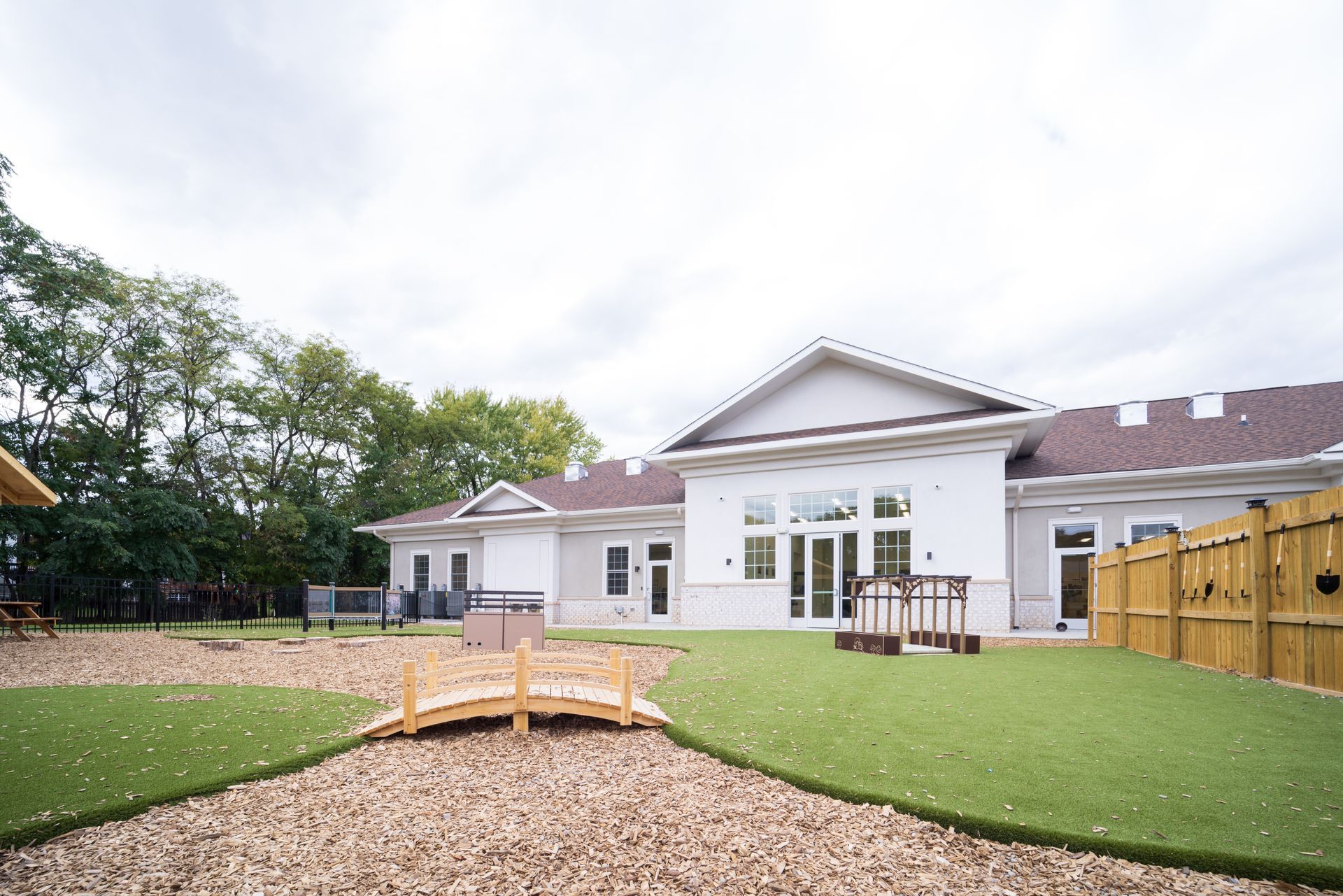 A large white house with a playground in front of it.