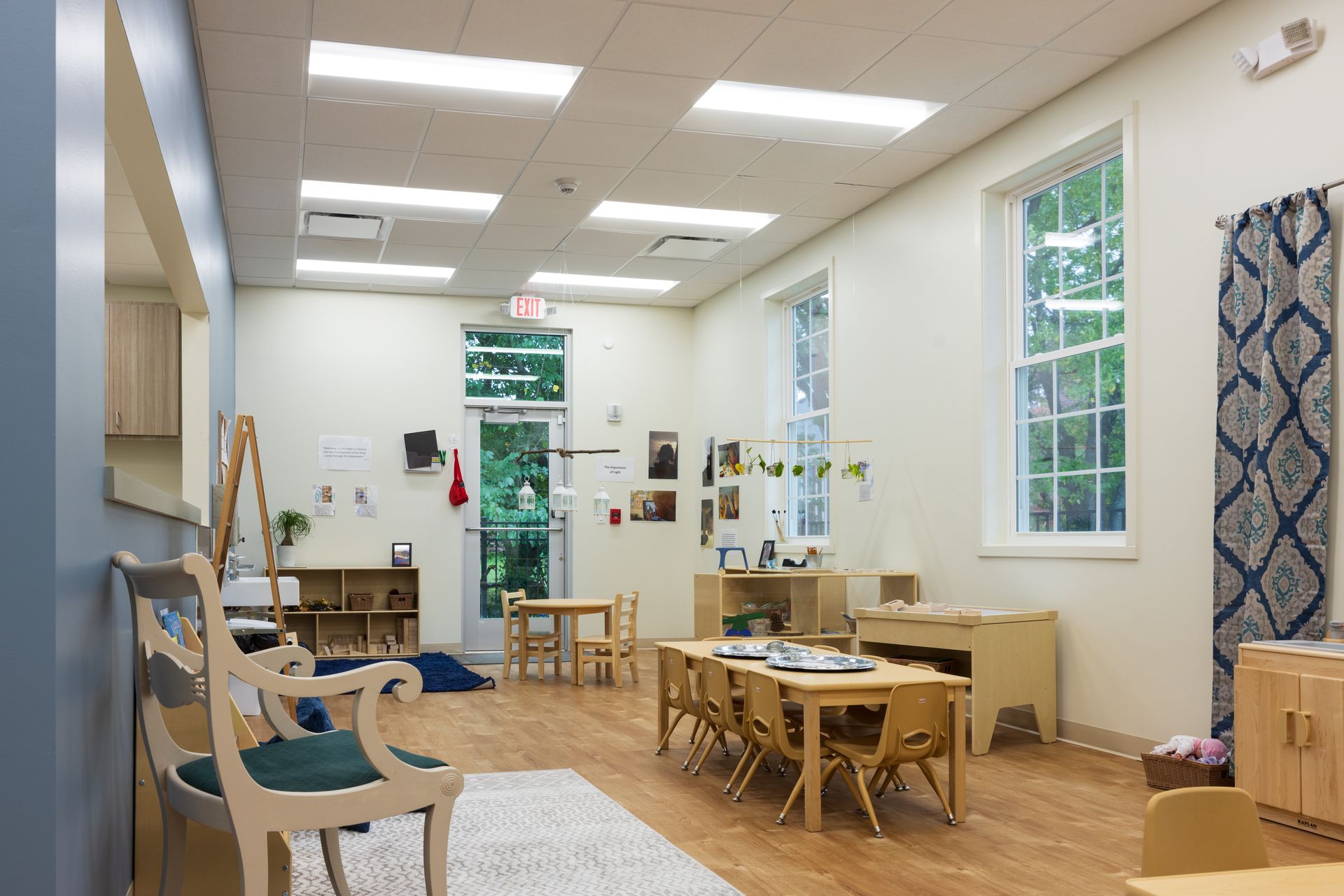 A classroom with tables and chairs and a bench.