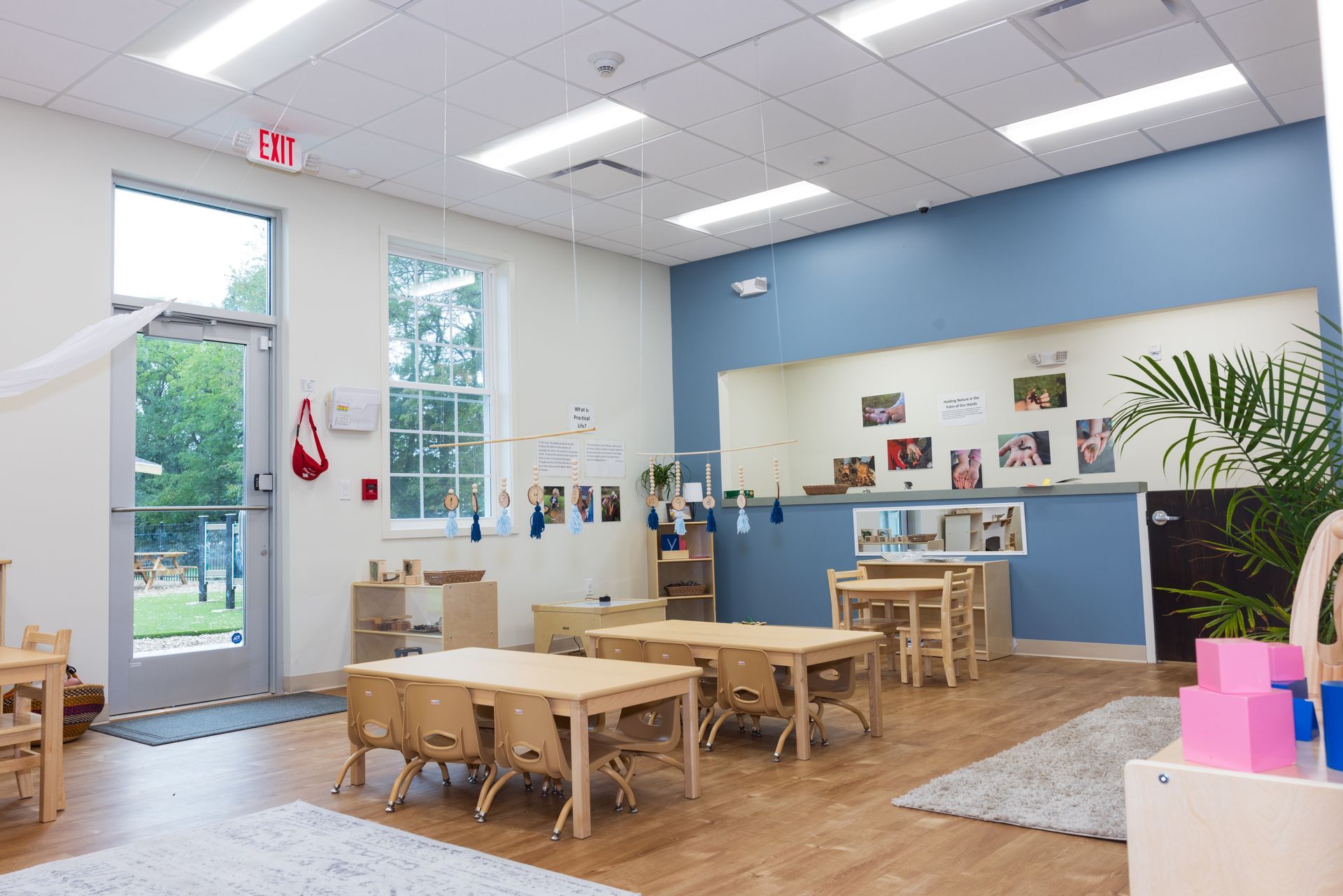 A classroom with tables and chairs and a counter.