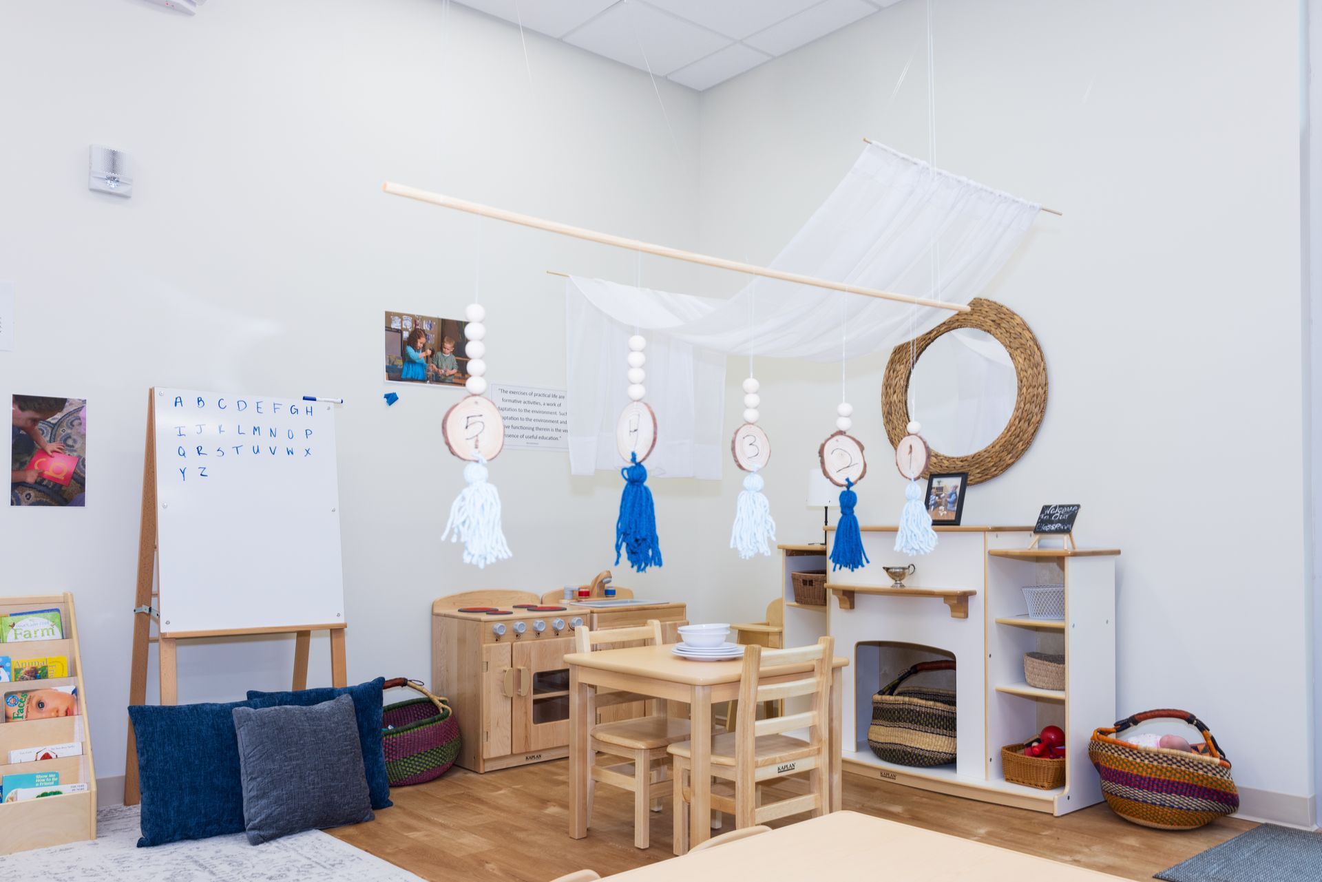 A classroom with a table and chairs and a fireplace.