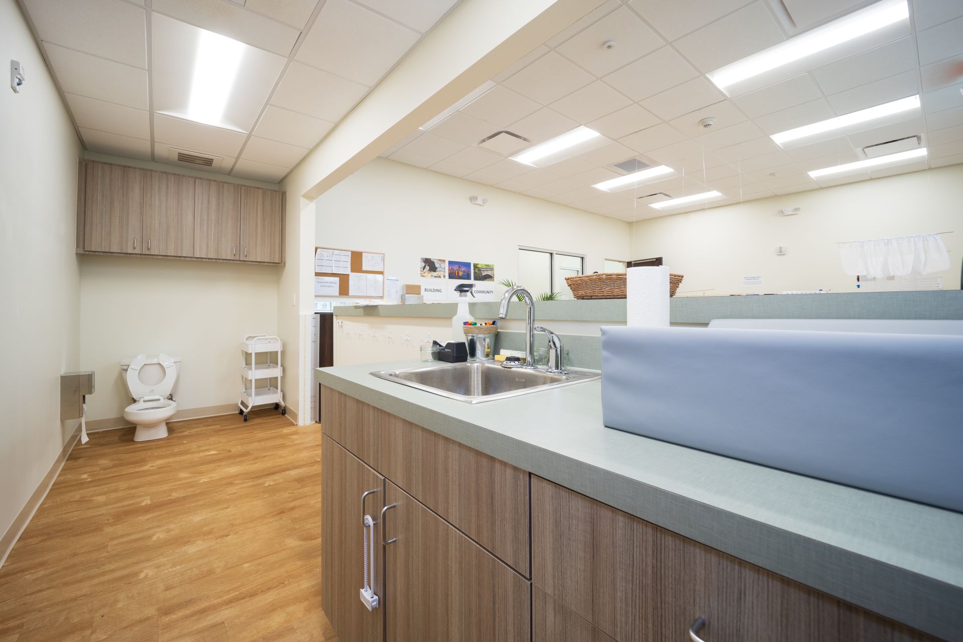 A bathroom with a sink , toilet and changing table.