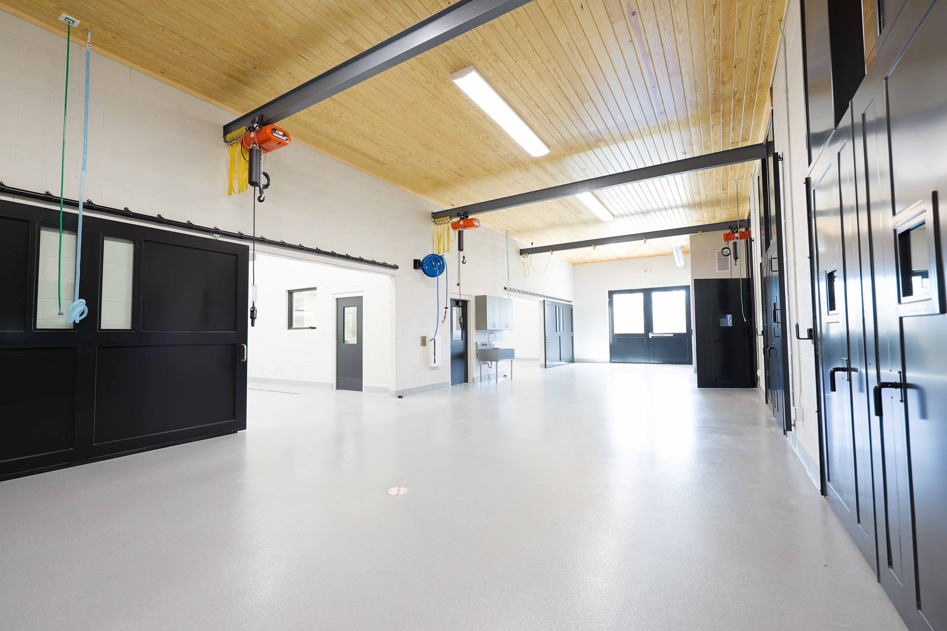 A large empty room with a white floor and a wooden ceiling
