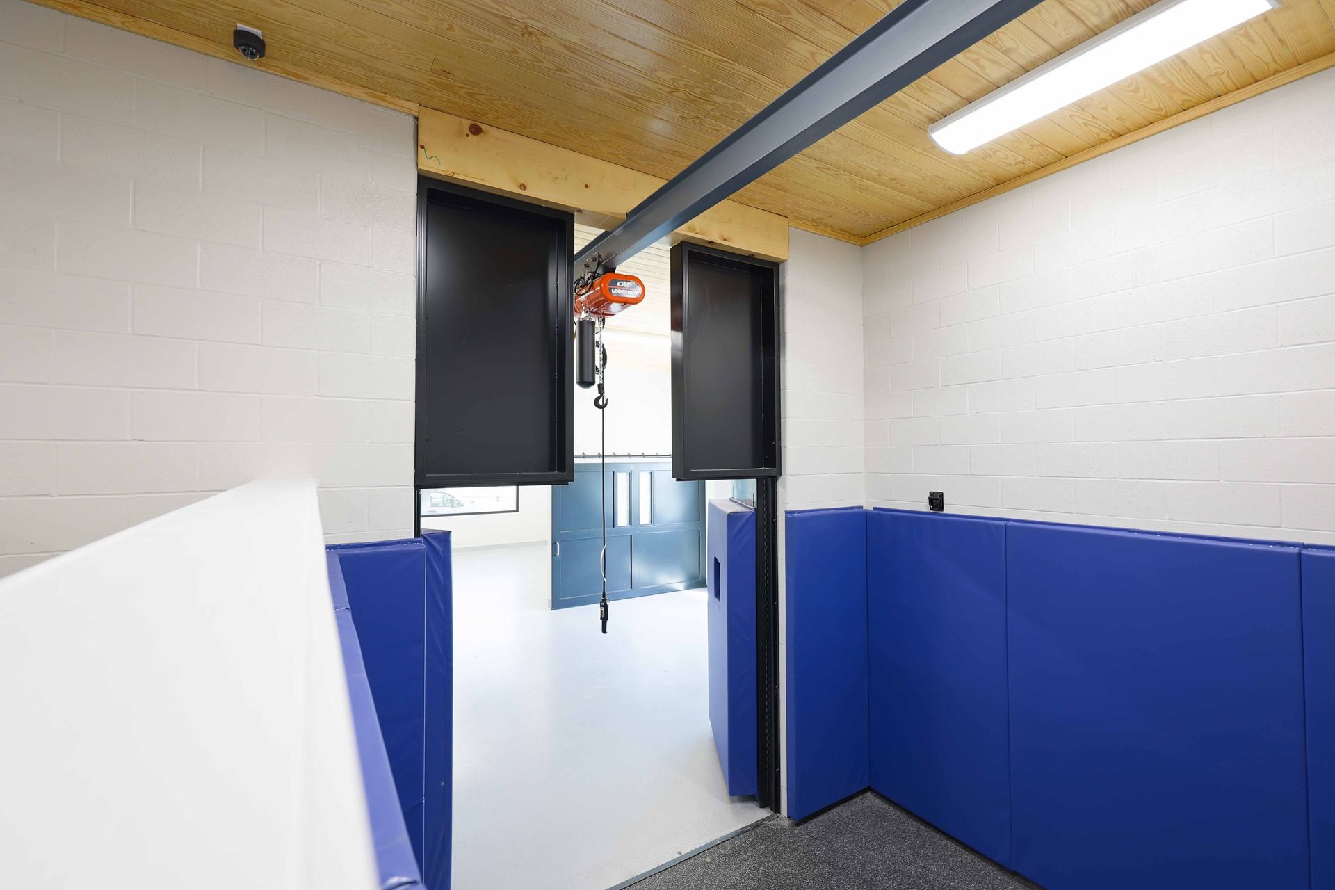 A room with a blue wall and a black door.