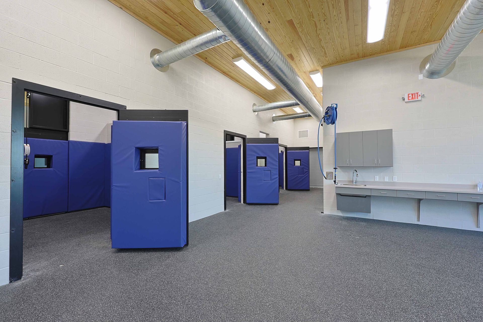 A large room with a lot of blue boxes and a sink.