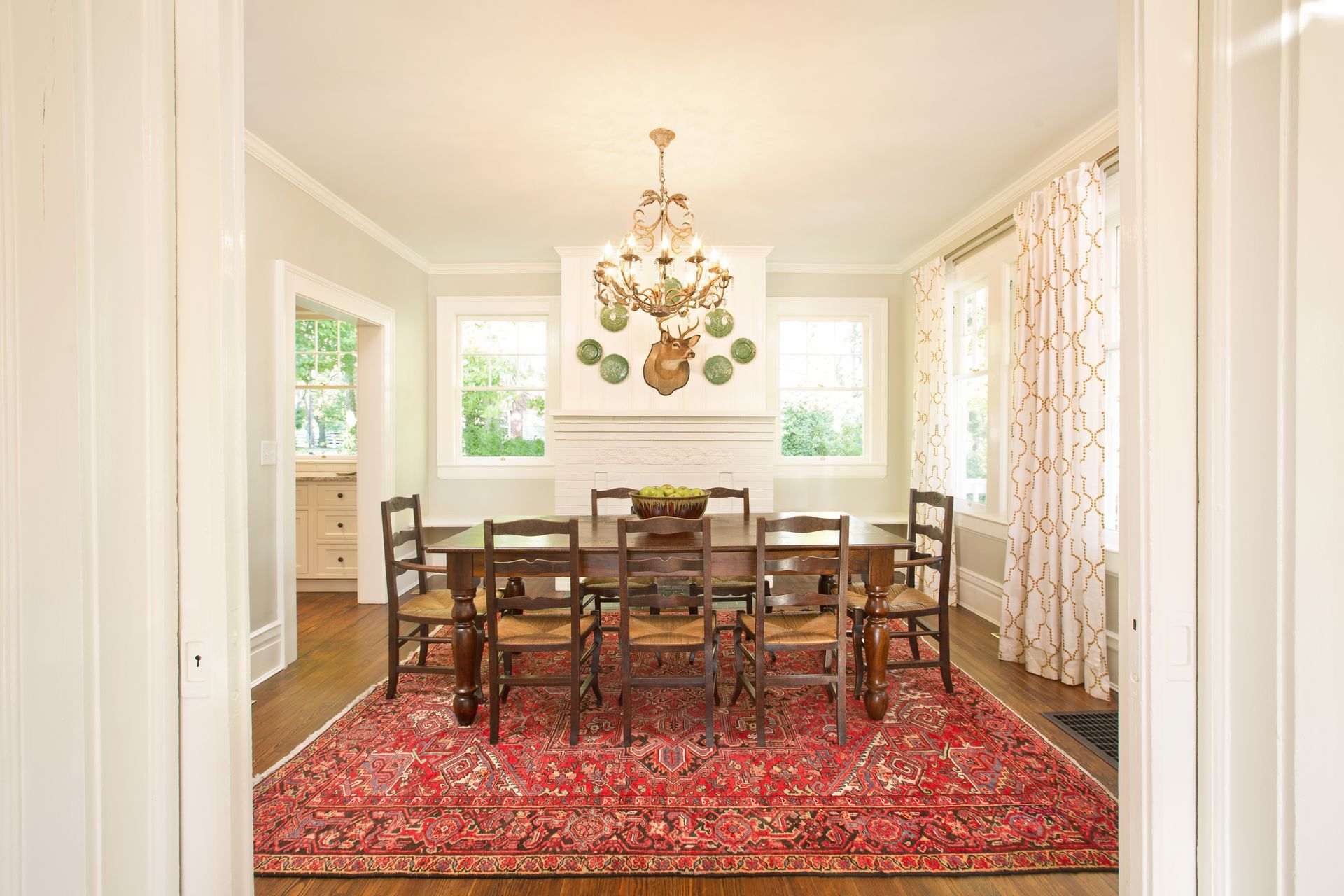 A dining room with a table and chairs and a rug.