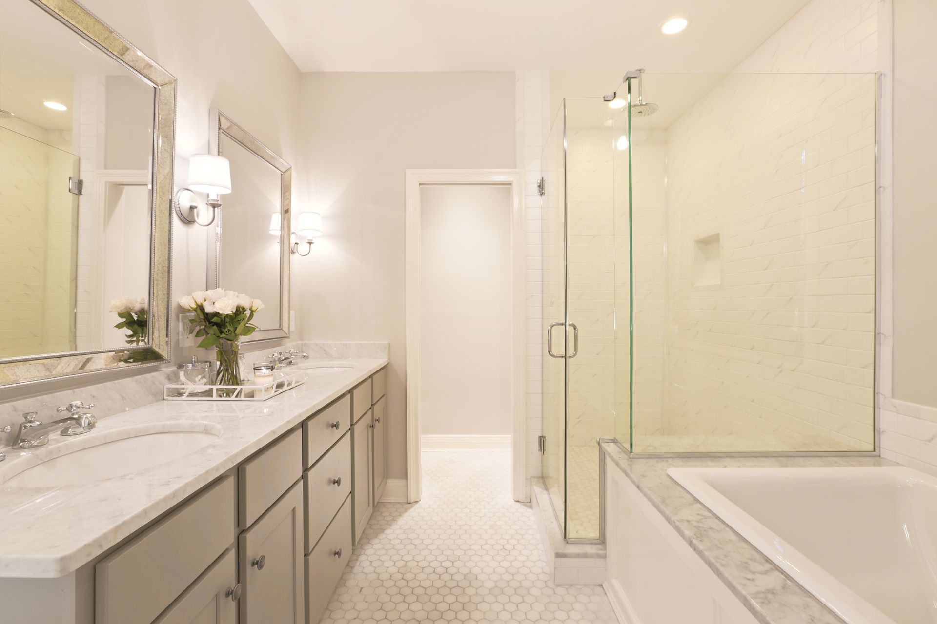 A bathroom with two sinks , a tub , and a walk in shower.