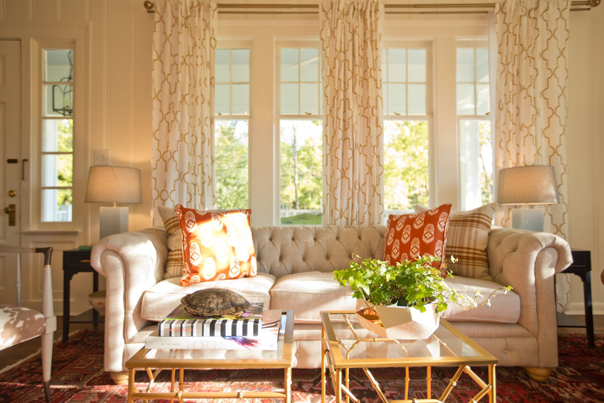 A living room with a couch , coffee table , and lots of windows.