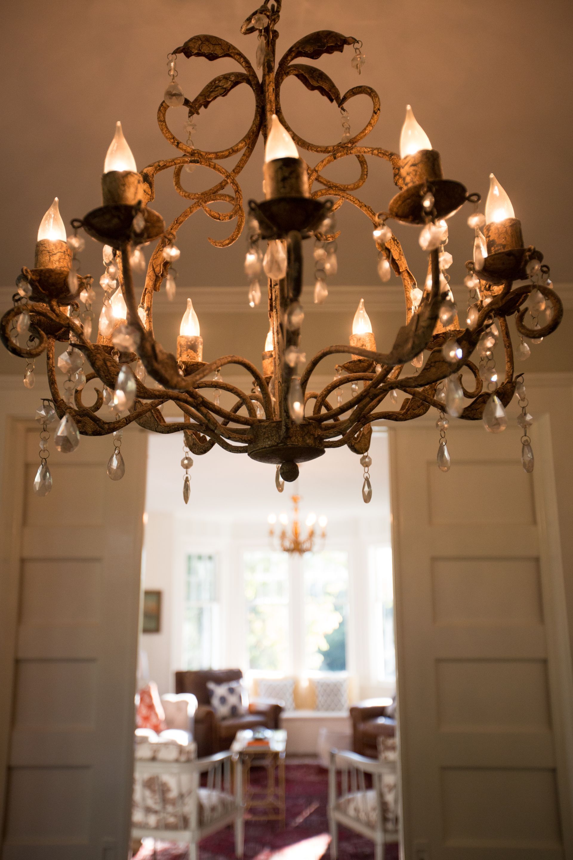 A chandelier is hanging from the ceiling in a living room.