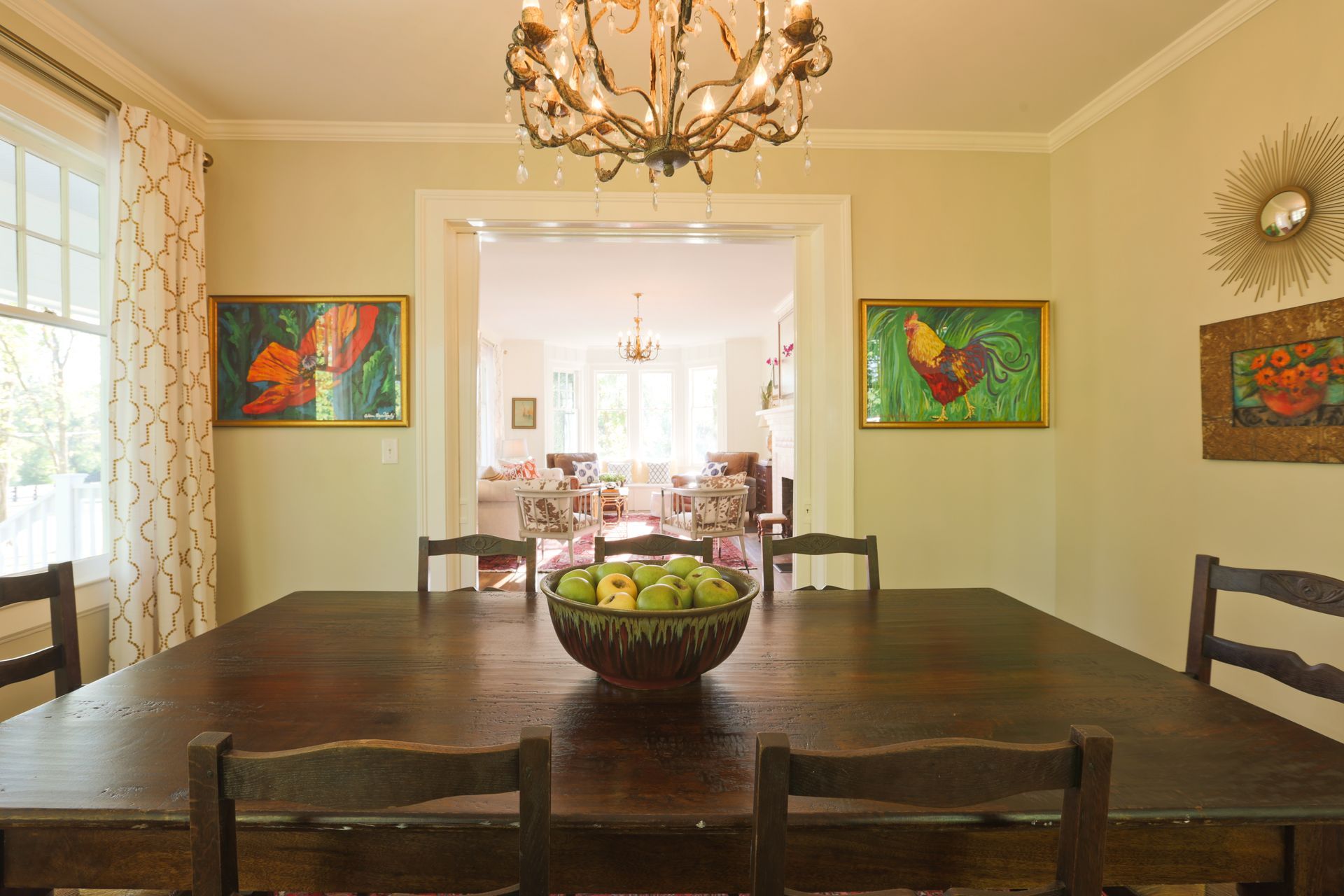 A dining room table with a bowl of apples on it