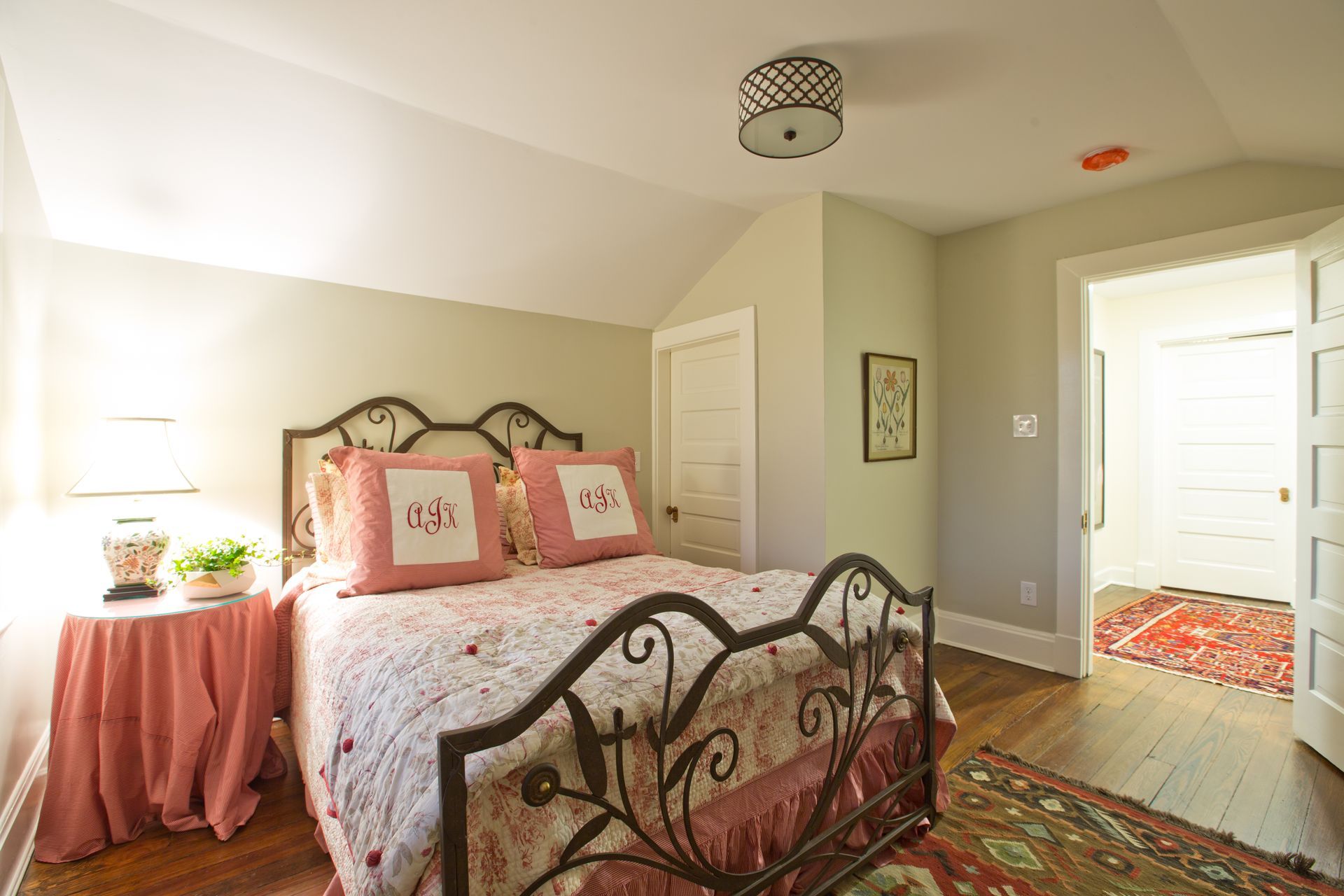 A bedroom with a bed , two tables , and a rug.