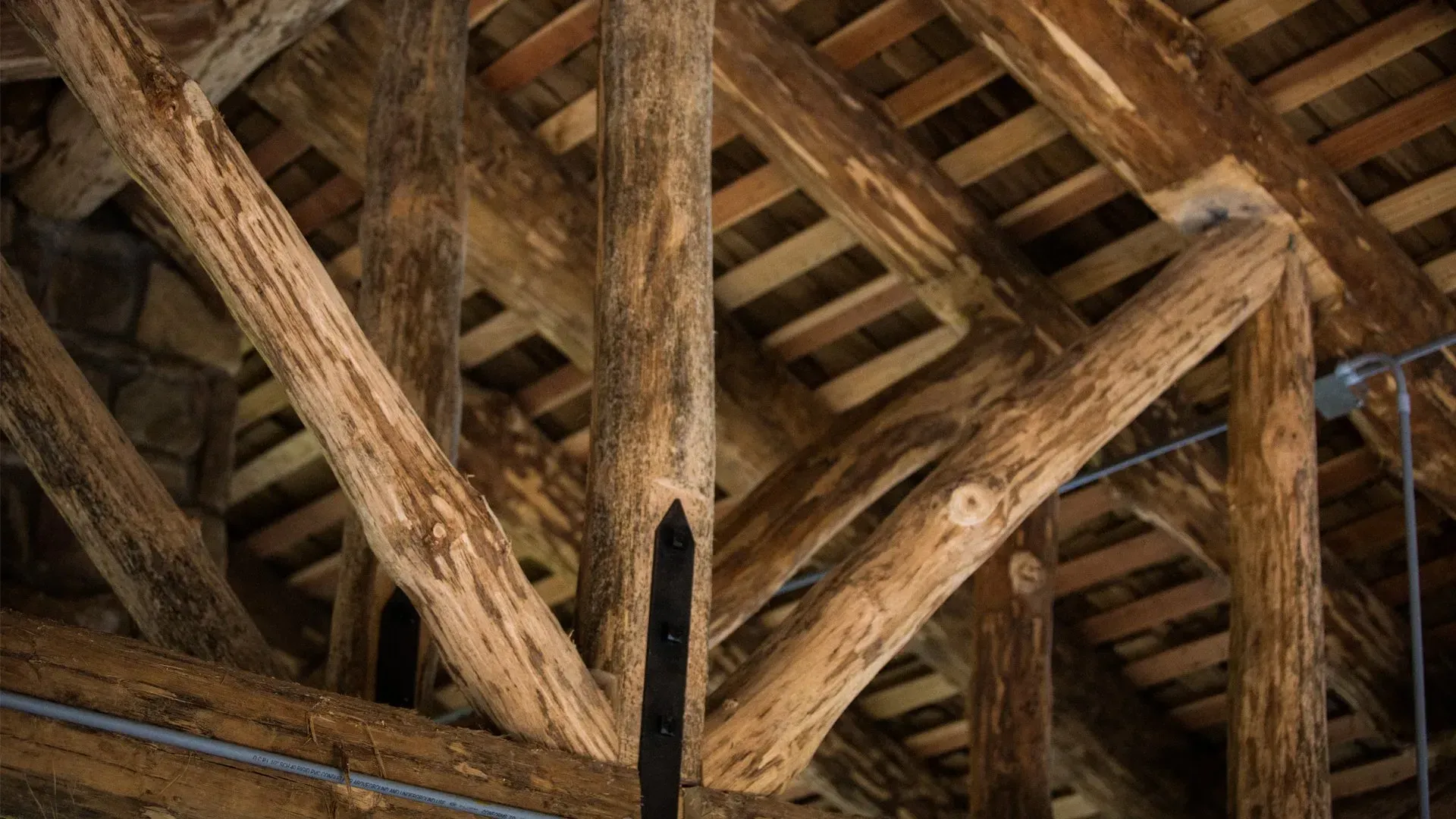A close up of the ceiling of a building made of wooden beams.