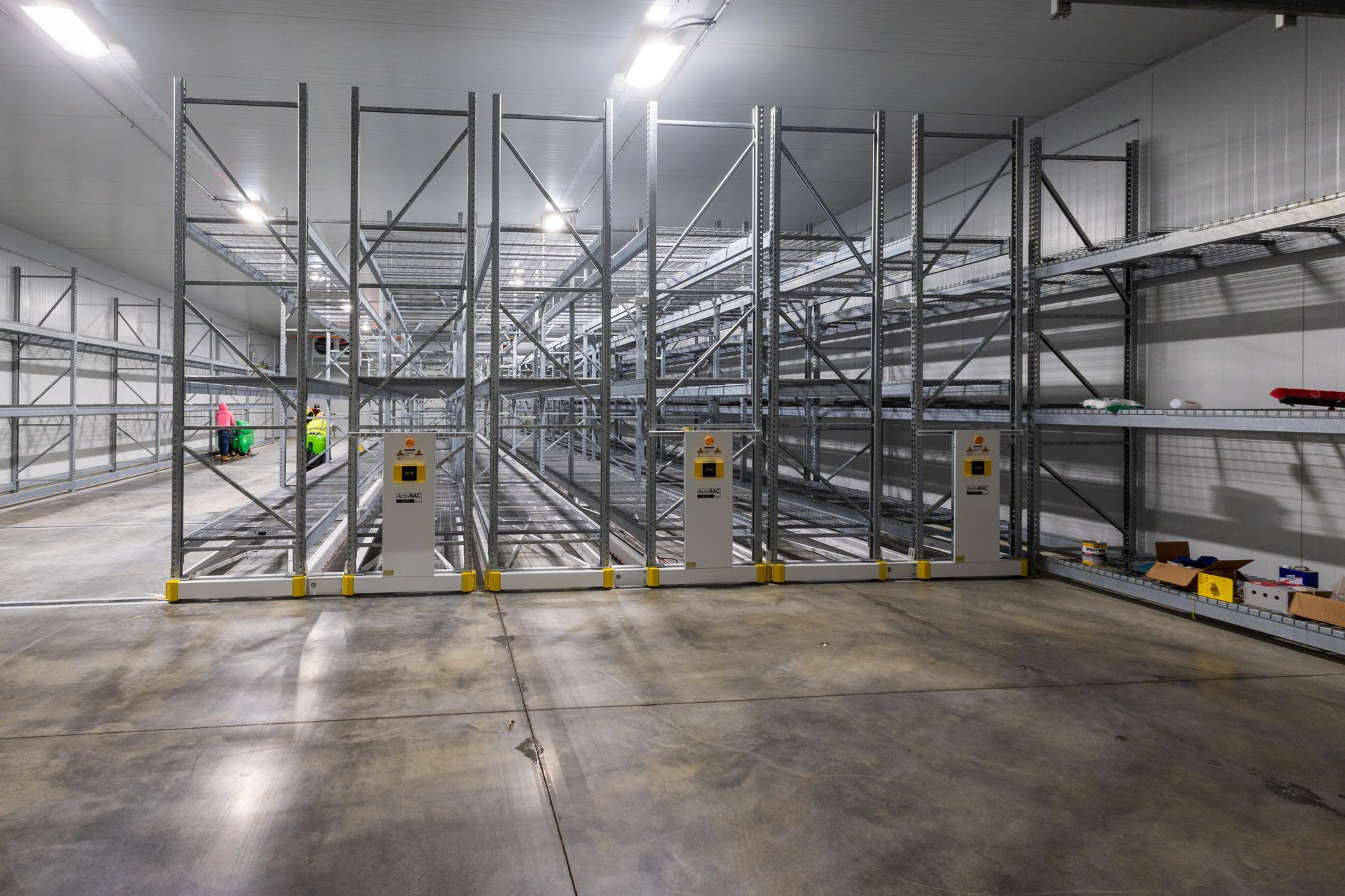 A large warehouse with lots of shelves and a concrete floor.