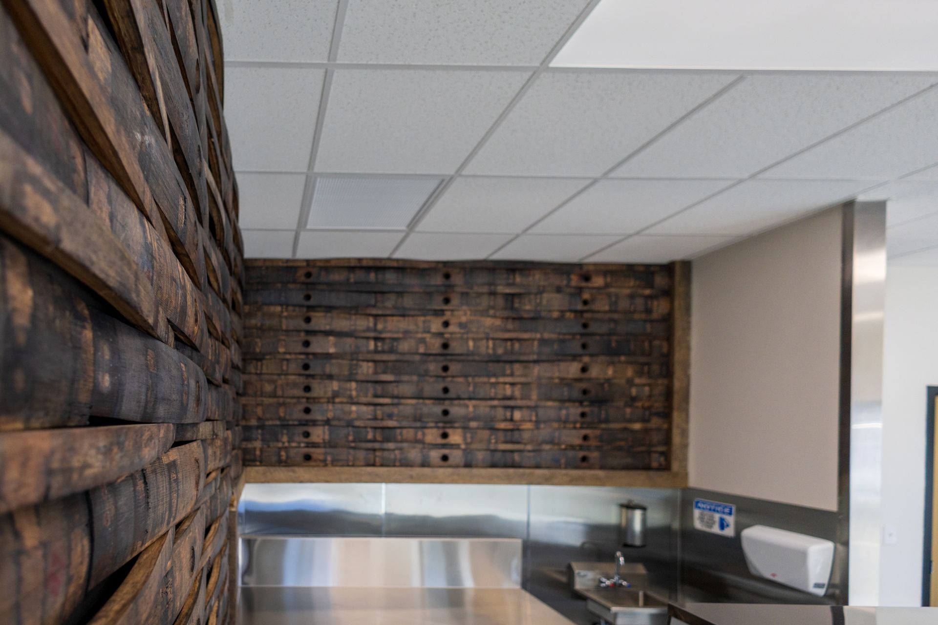 A kitchen with a wooden wall and a stainless steel counter top.