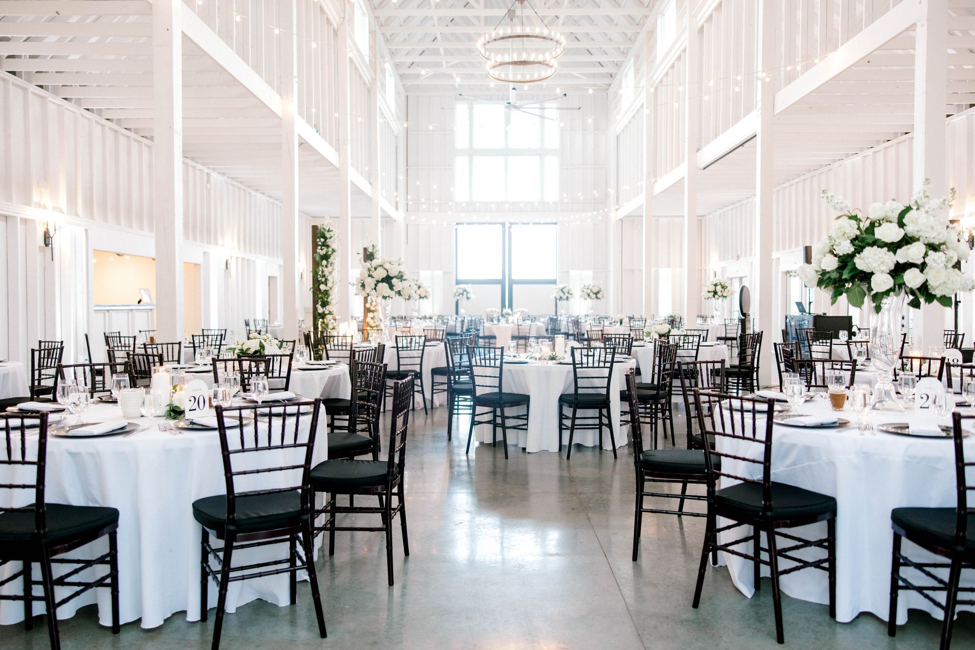 A large room with tables and chairs set up for a wedding reception.
