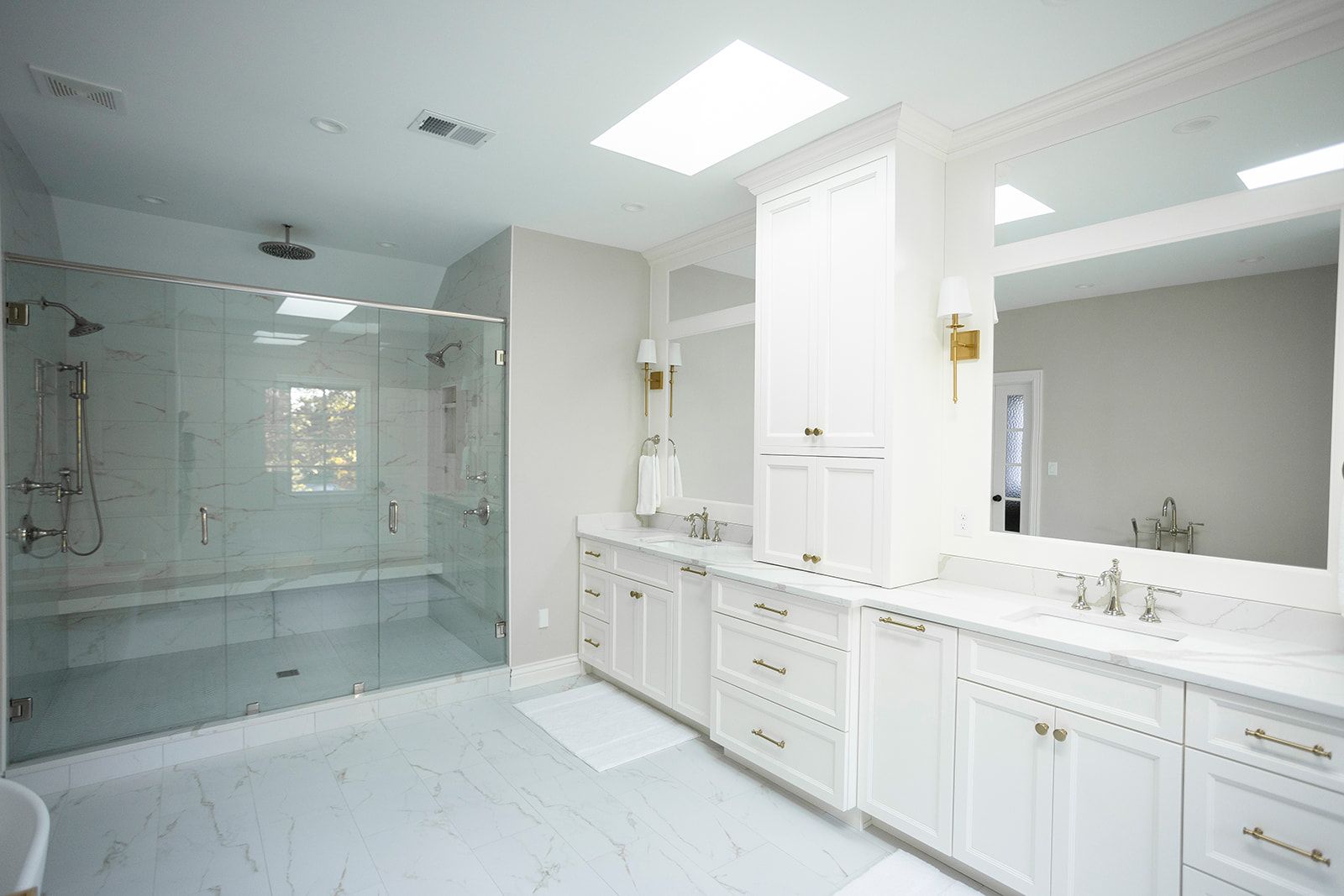 A bathroom with two sinks and a walk in shower.