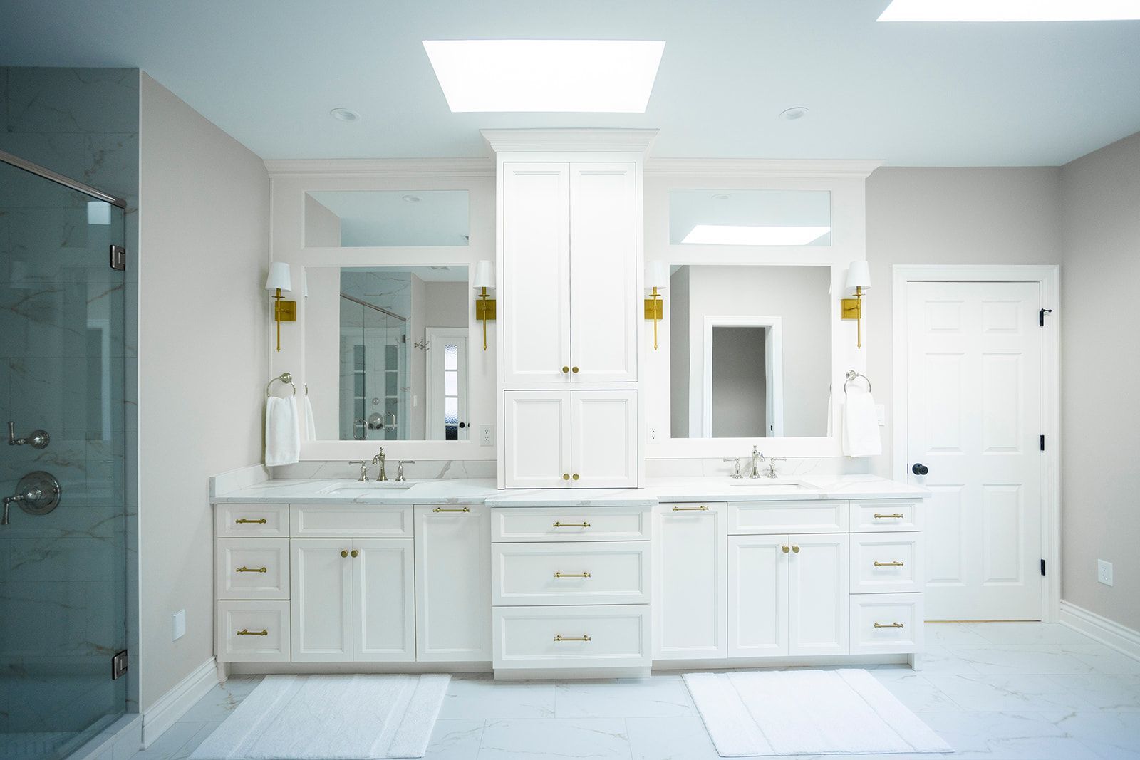 A bathroom with two sinks , two mirrors , and a walk in shower.