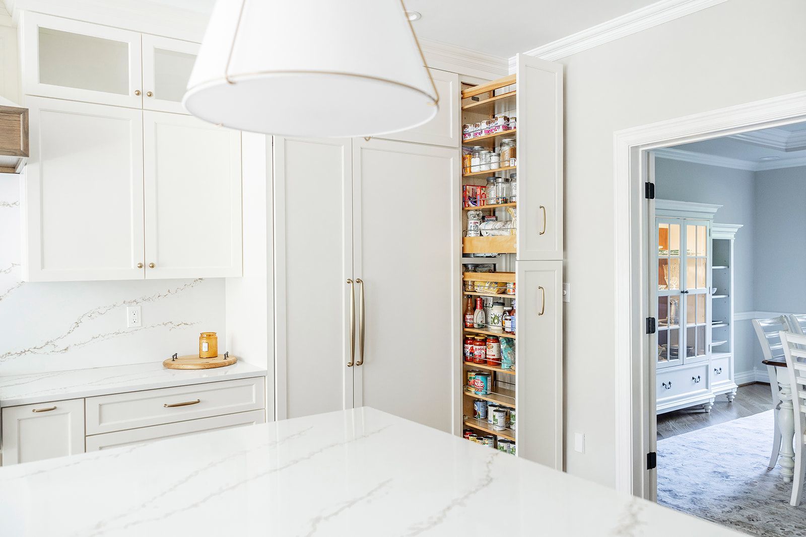 A kitchen with white cabinets and a large pantry.
