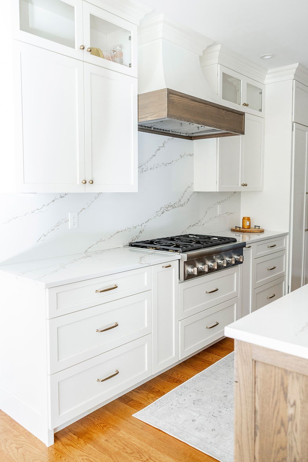 A kitchen with white cabinets and a stove top oven.