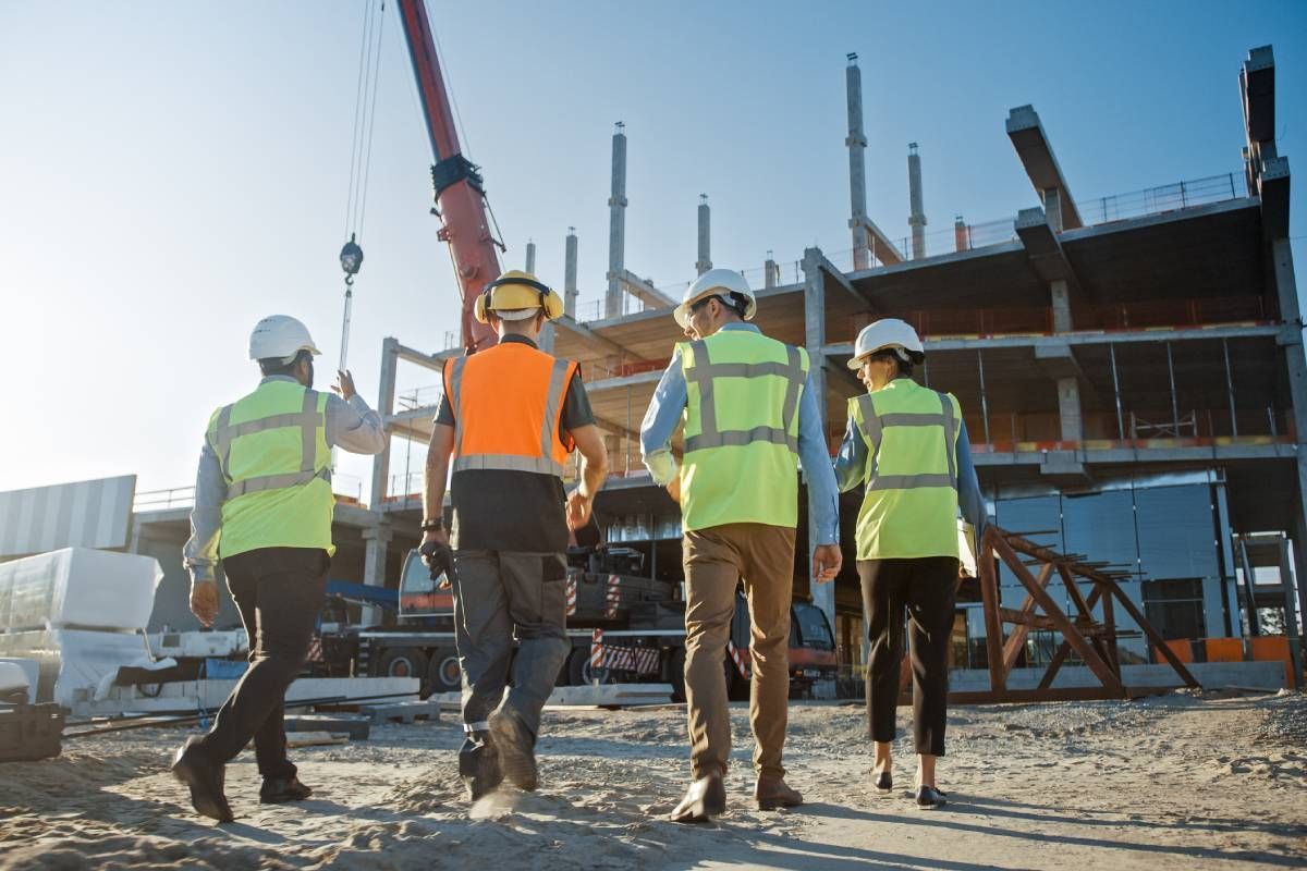 A group of construction workers are walking on a construction site.