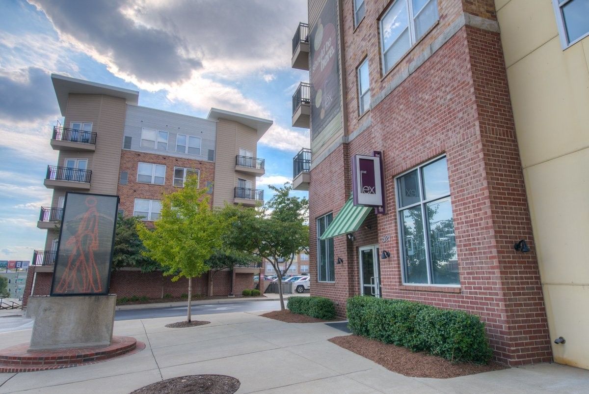 A brick building with a green awning and a statue in front of it