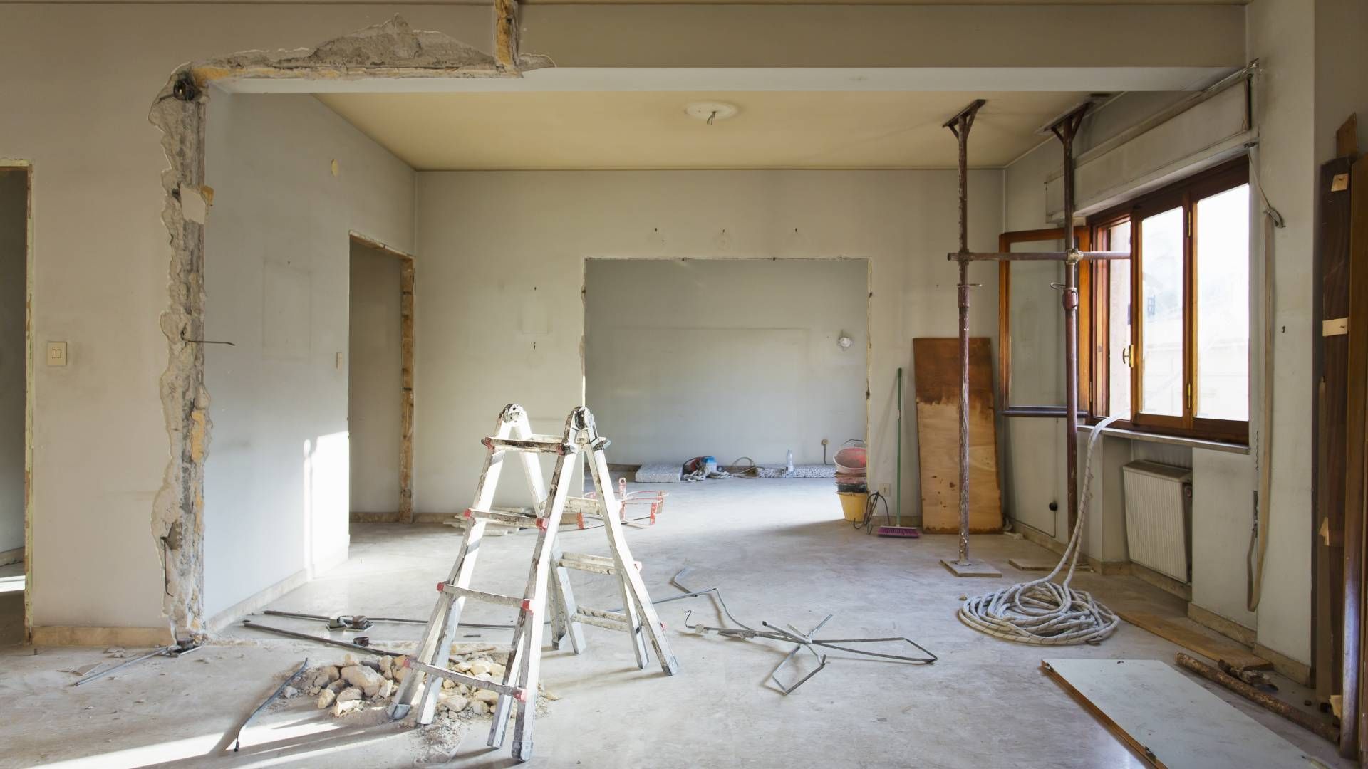 An empty room with a ladder in the middle of it.